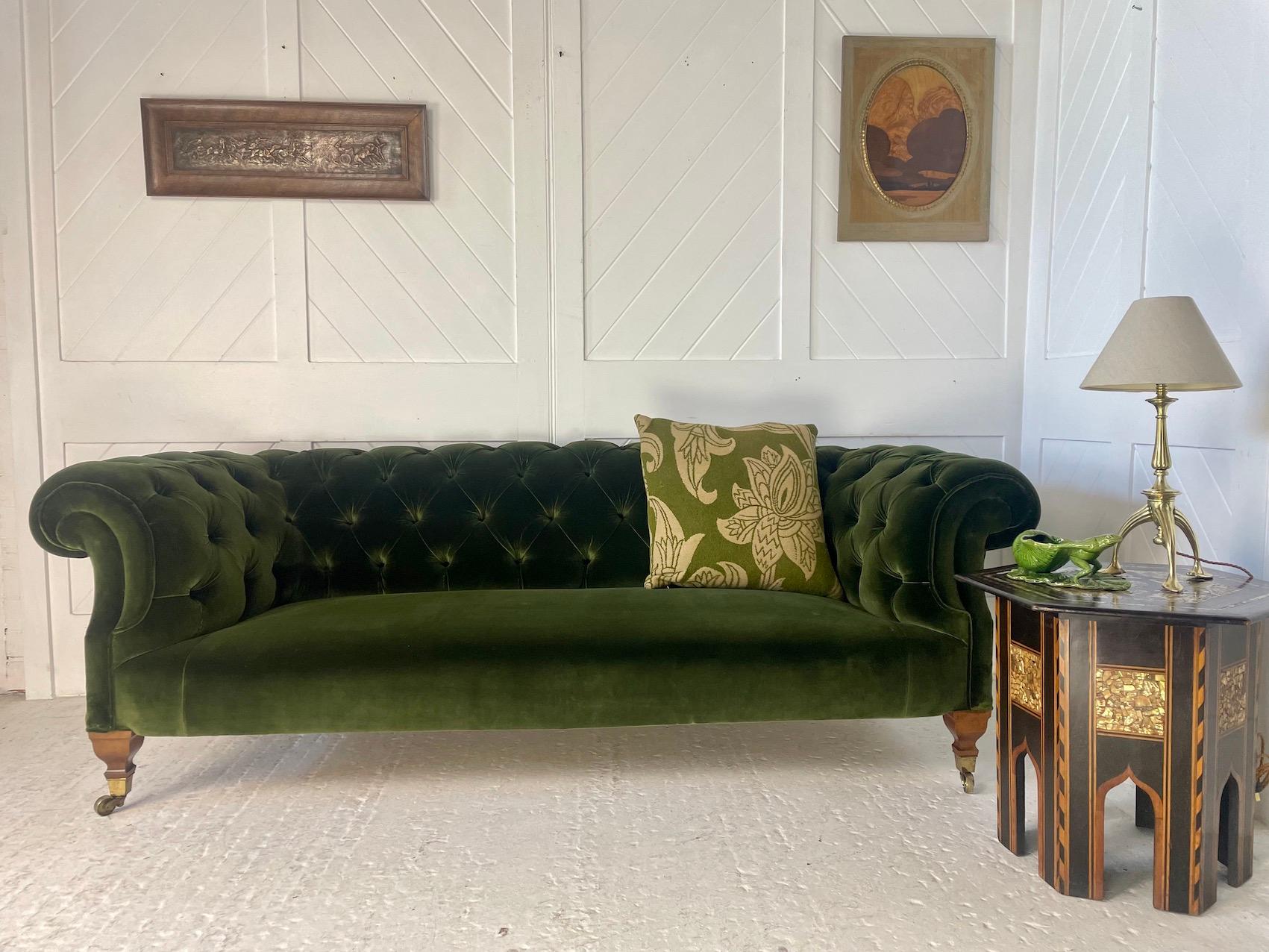 Exceptional quality Victorian button-back Chesterfield settee with scrolled arms

It has been traditionally re-upholstered and  re-covered using green velvet fabric by Lizzo

The shaped legs are in walnut and raised on brass castors - these castors