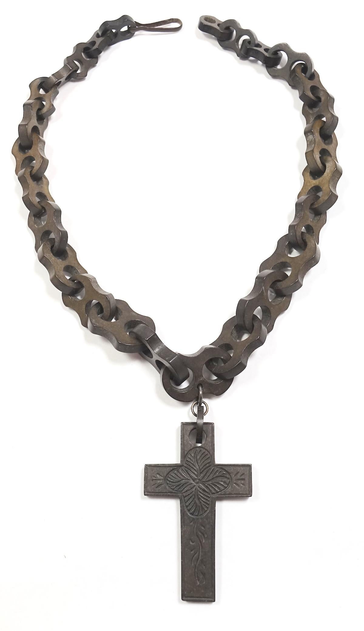 This Victorian Gutta Percha necklace features a heavily etched cross pendant on a continuous link chain with pressure closure.  Gutta Percha, like this, is made from the same wood and is considered collectible art. The cross pendant measures 2-3/4”