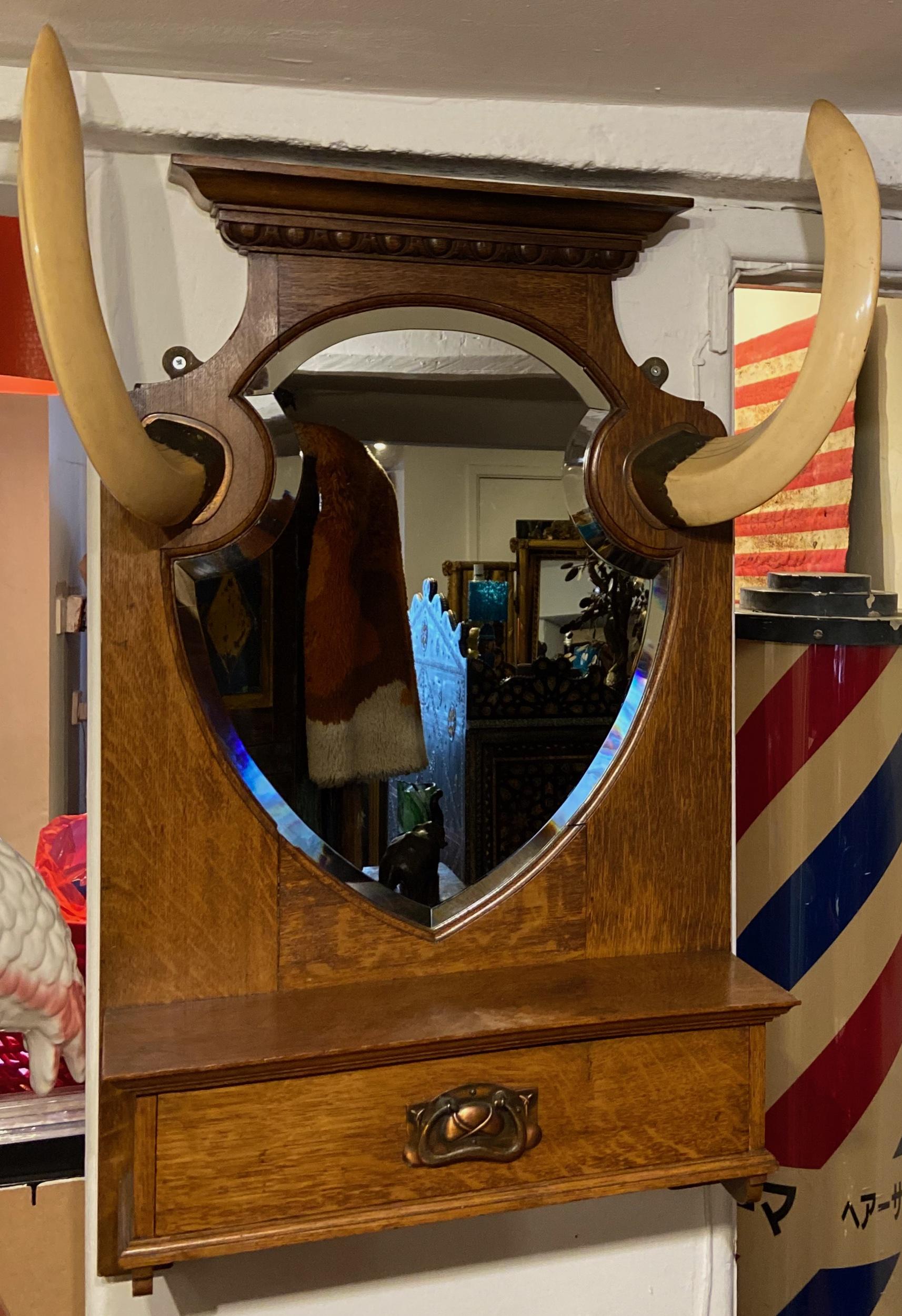 Outstanding Victorian late 19th century hall mirror.

Two horns held either side of the mirror. Has a tray draw to the bottom with detailed handle

A lovely sophisticated and refined piece suitable for any wall in the home.

Approx size 80 cm