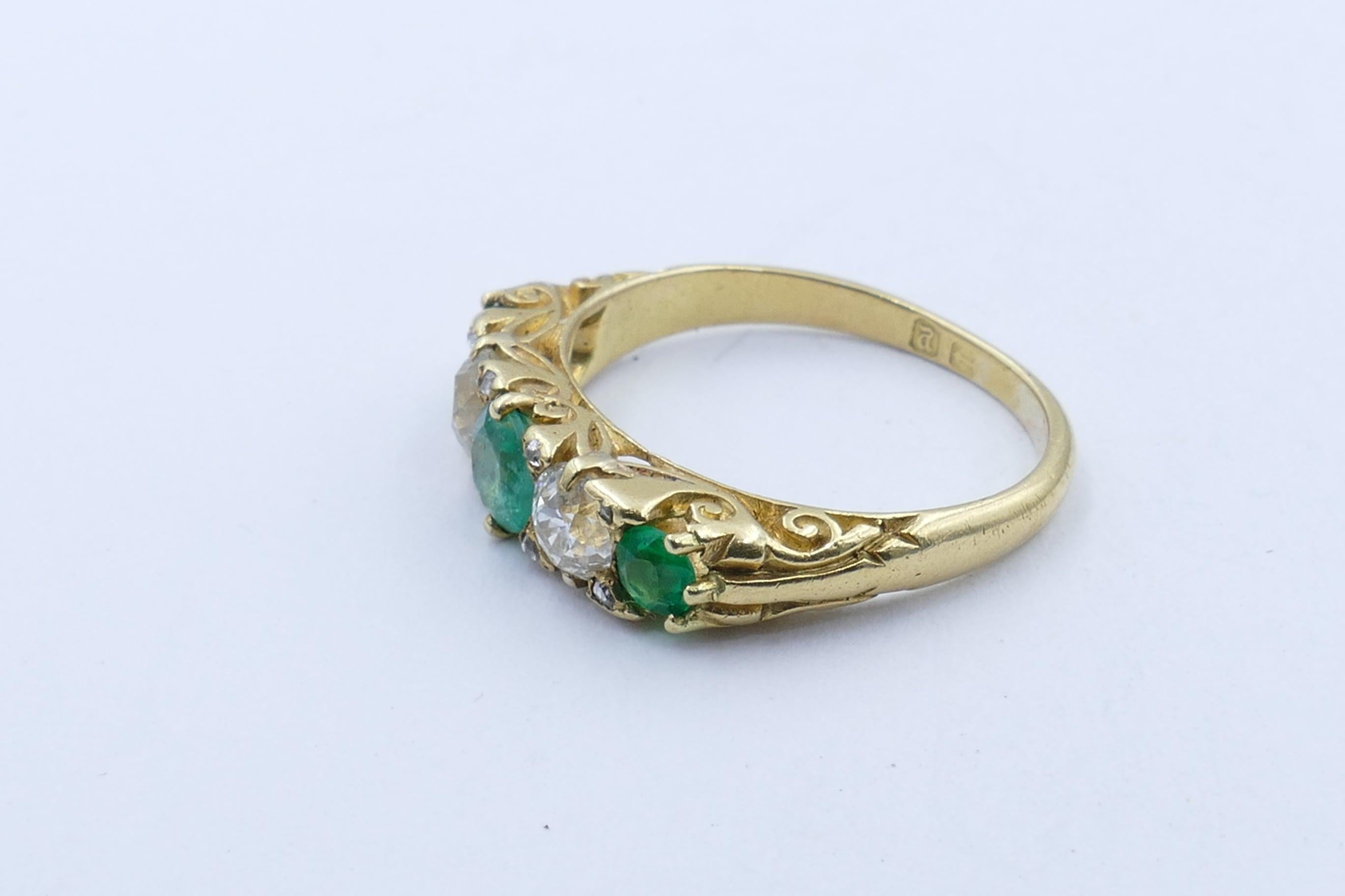 Hallmarked Birmingham 1898, this traditional Victorian Band Ring is in excellent condition for its age.
It features 3 Emeralds of bluish-green tone, only slightly included, & is flanked by 2 Old European cut Diamonds, totalling over half a carat