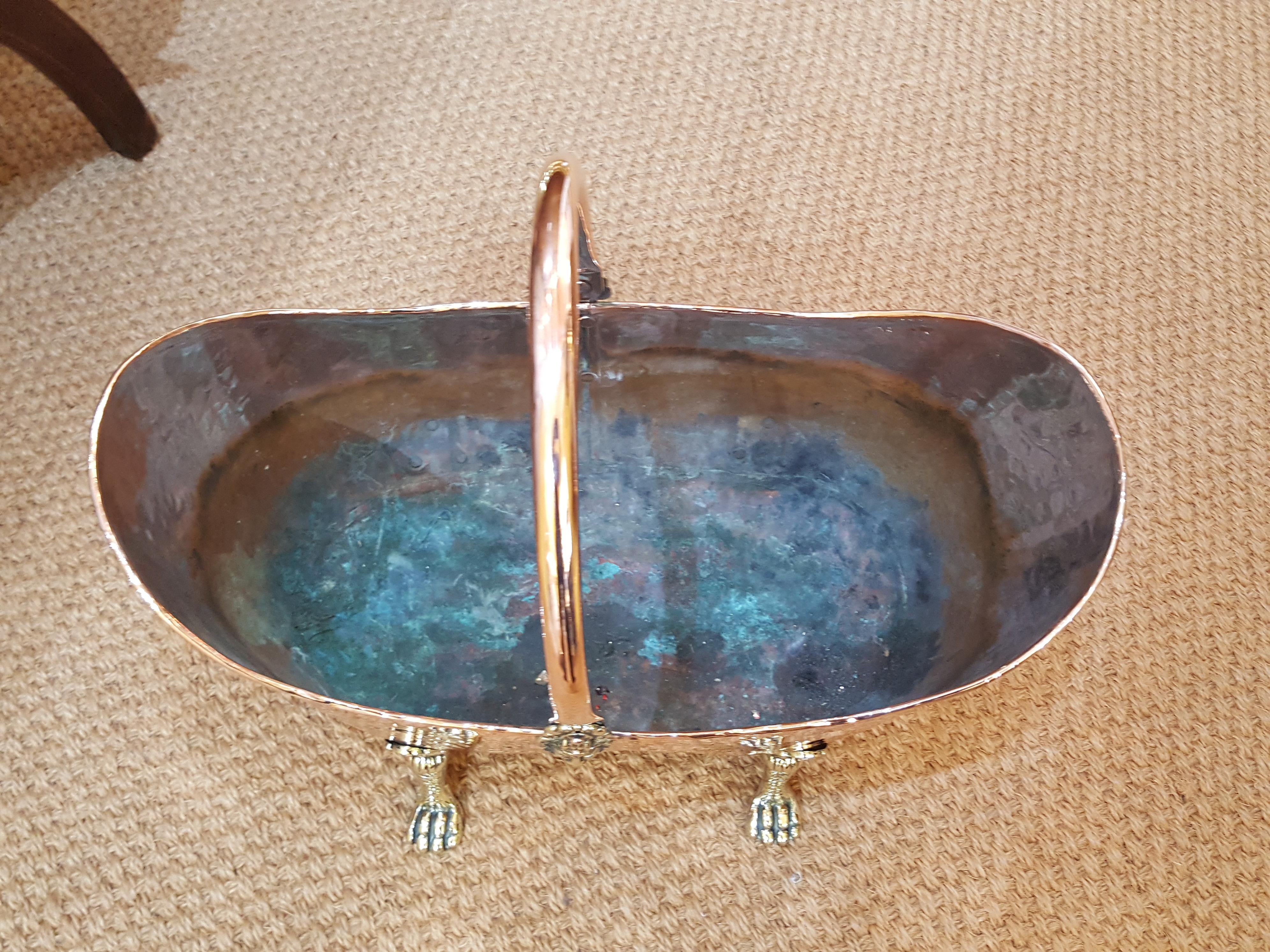 Victorian decorative hammered copper and brass kindling basket with lion mask handle and paw feet
Measures: 18