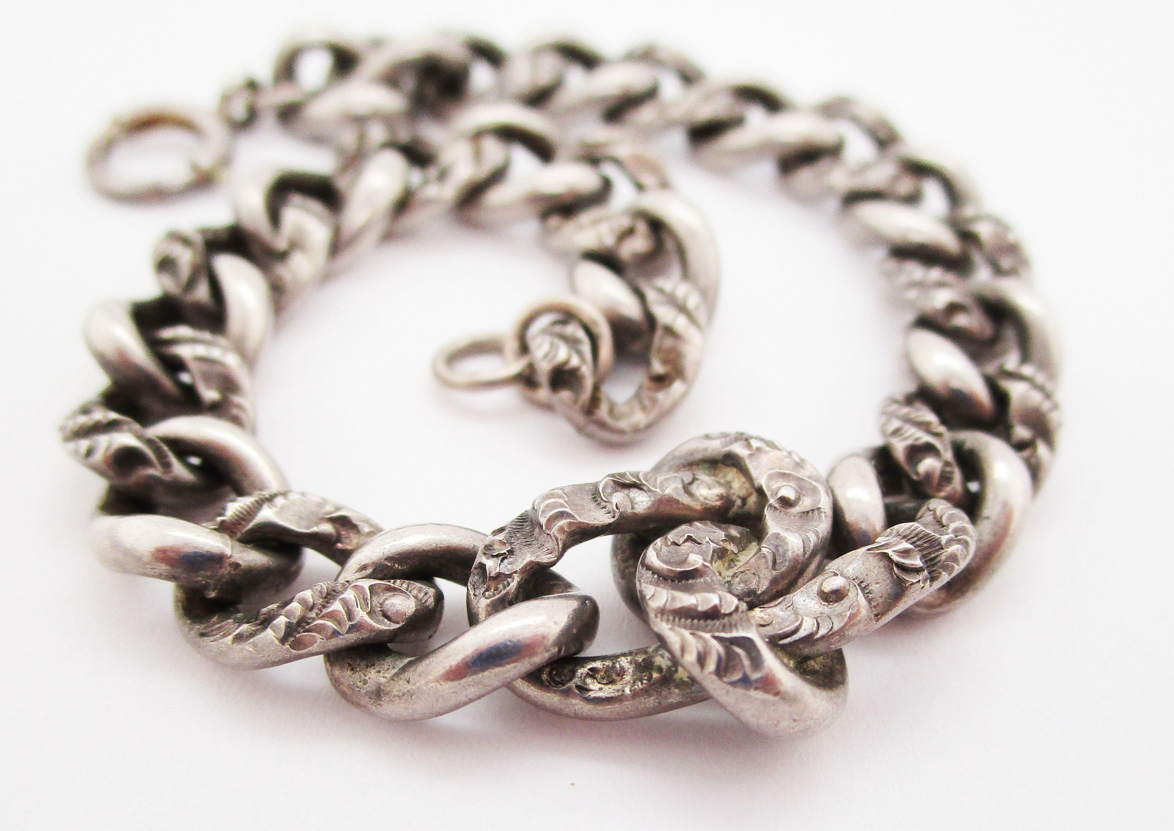 This stunning engraved chain bracelet is Victorian, dating from the late 1890s, and is in sterling silver. The links of the chain are solid and dramatic. Every other link is engraved with a feather-like design that takes a simple chain bracelet and