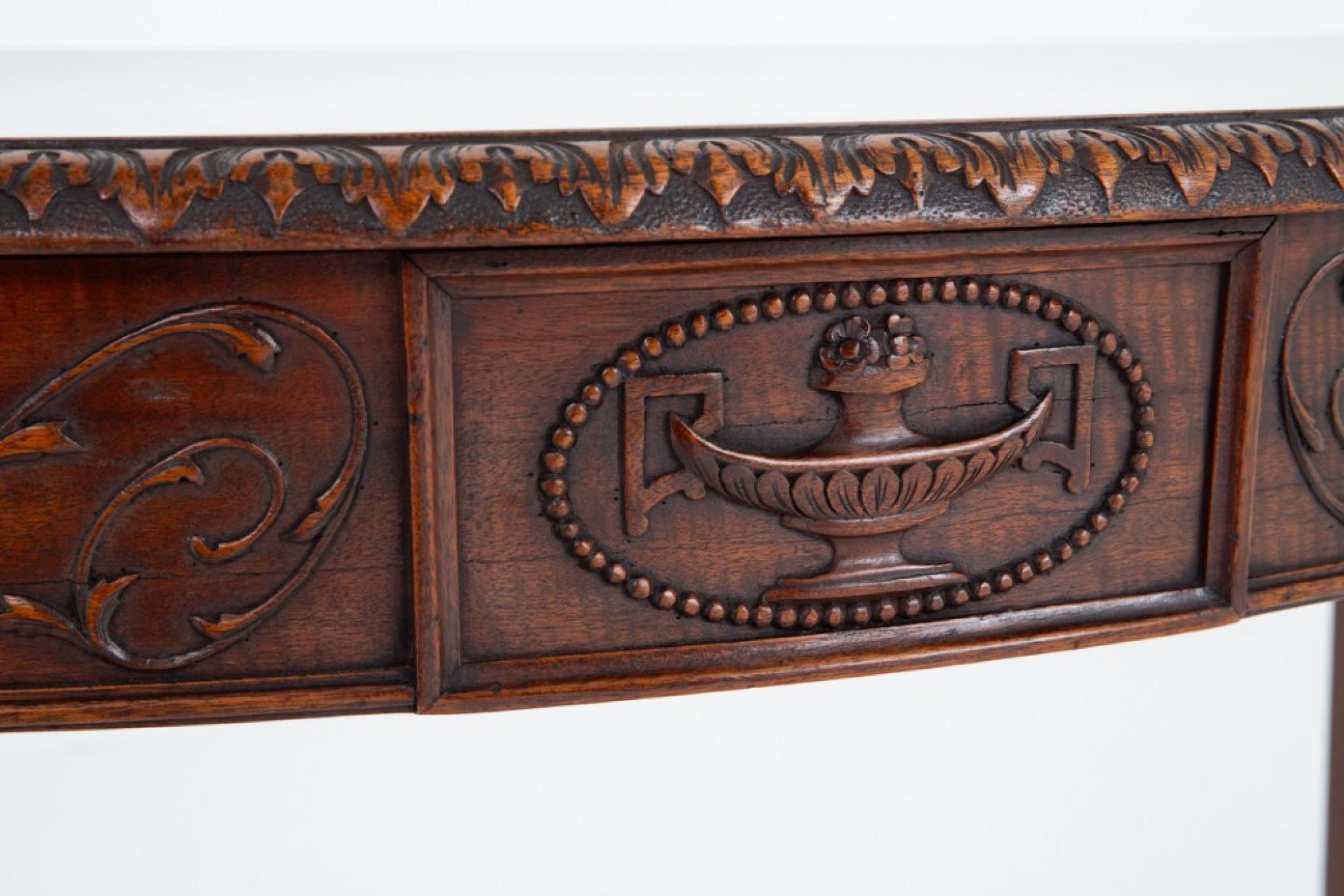 Here we have a good quality Adams style mahogany console table.
Circa 1880
The table is raised upon tapered legs with hare bell carved detail and spade feet.
The frieze of the table featuring a centralized carved Adams style urn and carved swags and