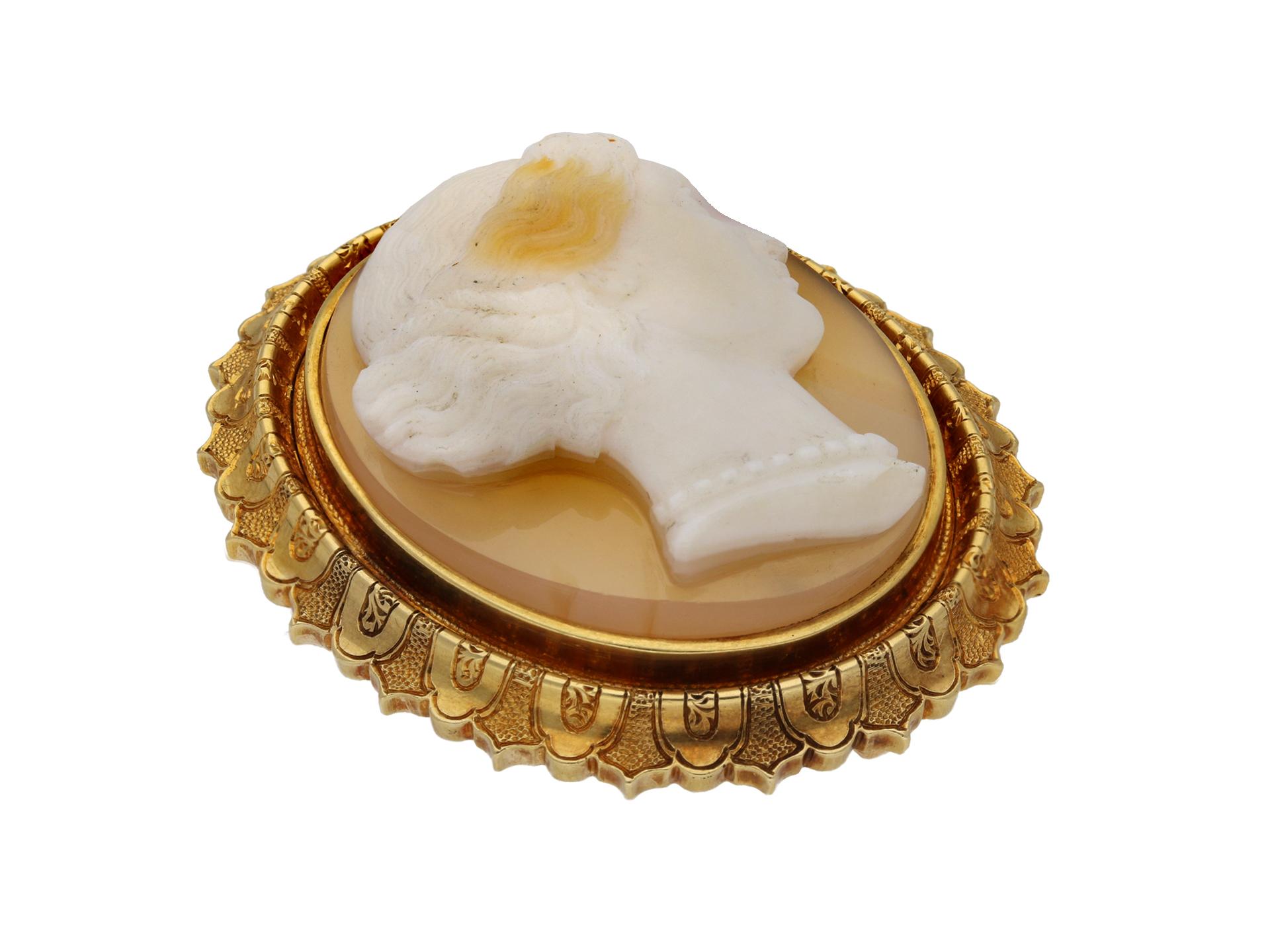 Victorian hardstone cameo brooch. Set with an oval cameo in hardstone depicting the profile of a woman in the classical style, featuring a decorative engraved border and fitted to reverse with secure hinge pin. Marked yellow gold, maker's mark 'PR',