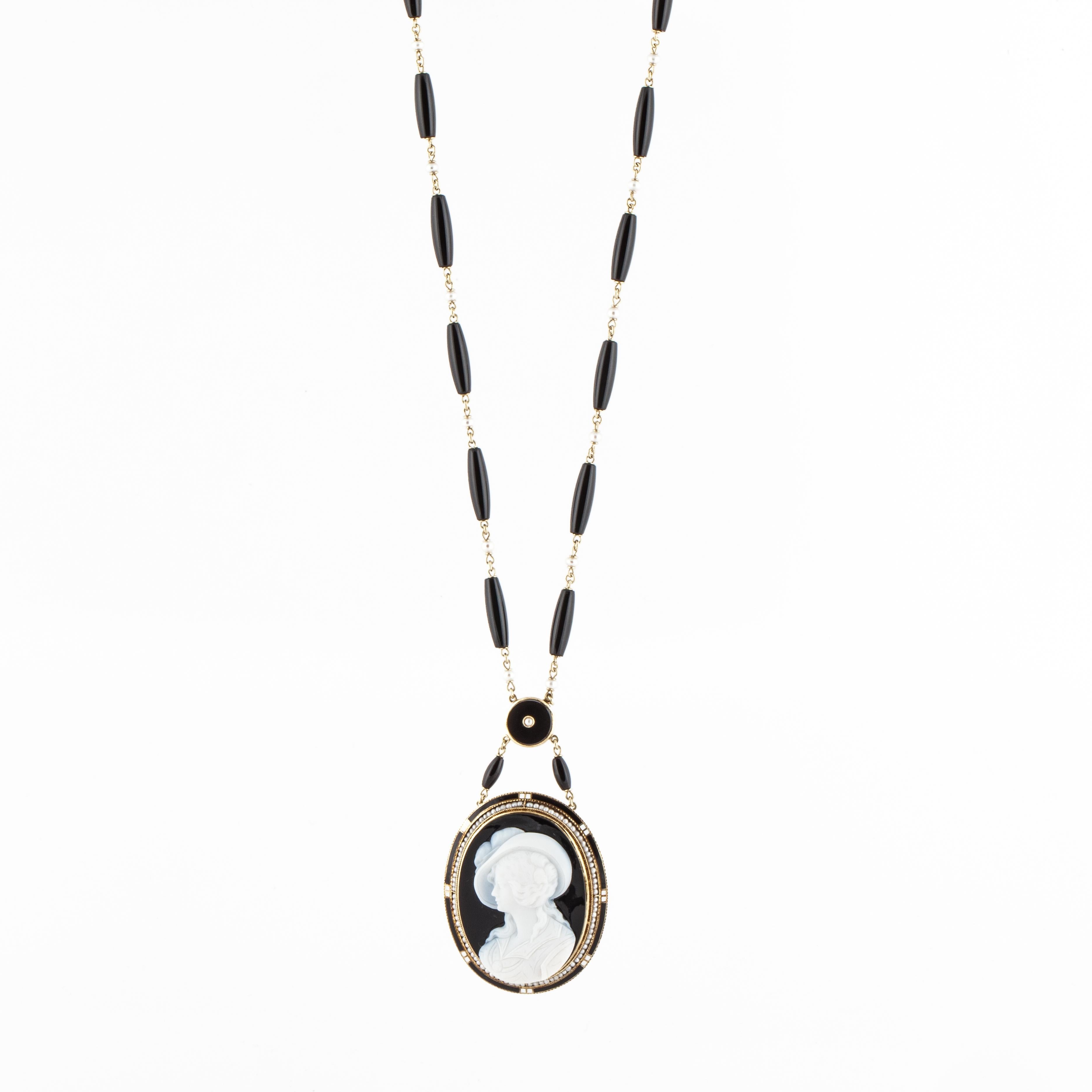 14K yellow gold hardstone cameo necklace with cultured pearls in the chain and seed pearls surrounding the cameo frame.  Chain is elongated onyx beads interspersed with pearls.  The cameo is a profile of a lady wearing a hat.  Necklace measures 24