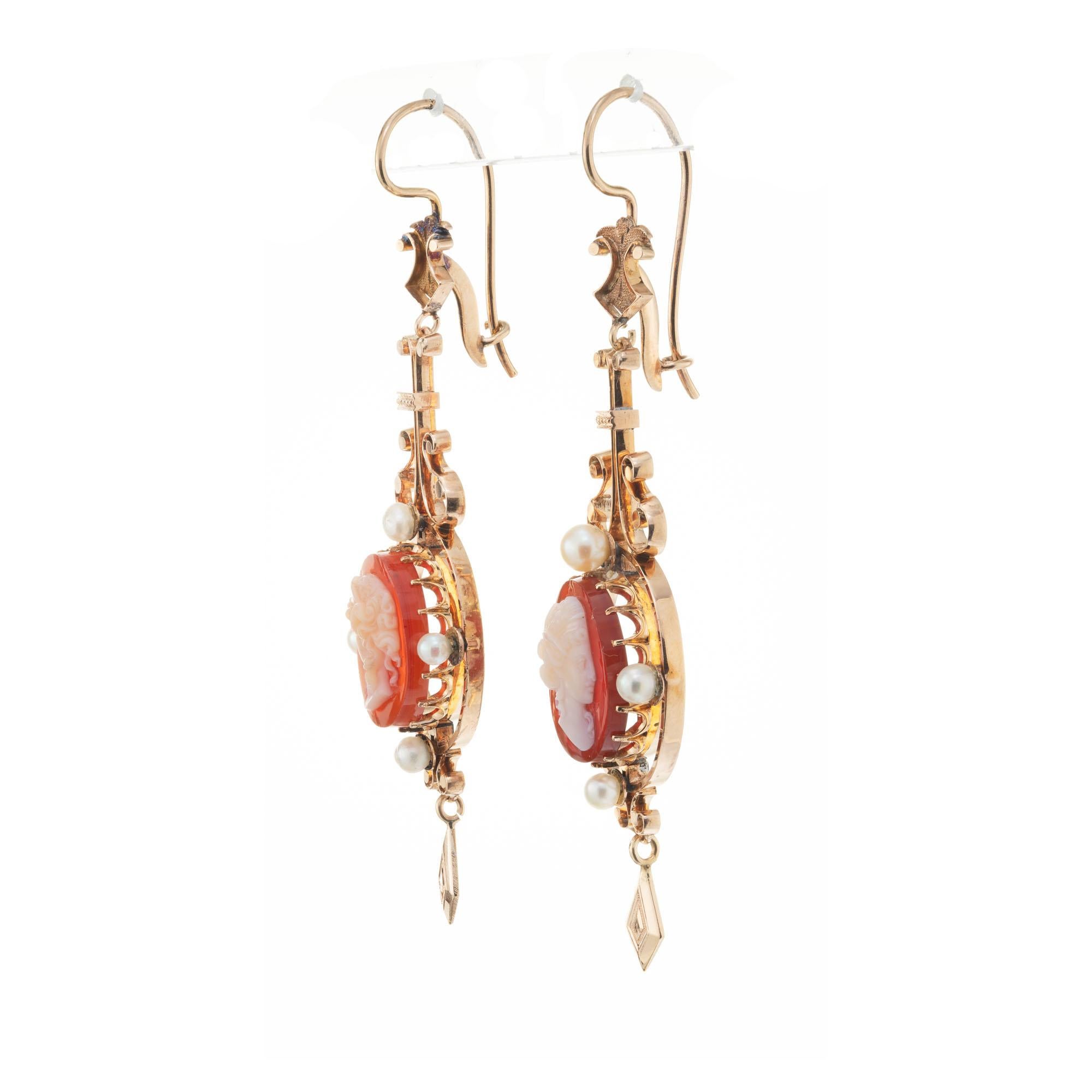 Pendant dangle style 1900’s 15k rose gold carved hardstone cameo dangle earrings with natural pearl accents, one or two may have been replaced with cultured pearls.

2 crème orange brown hardstone cameos
8 gray crème pearls, 3.4mm
15k rose gold 
15k