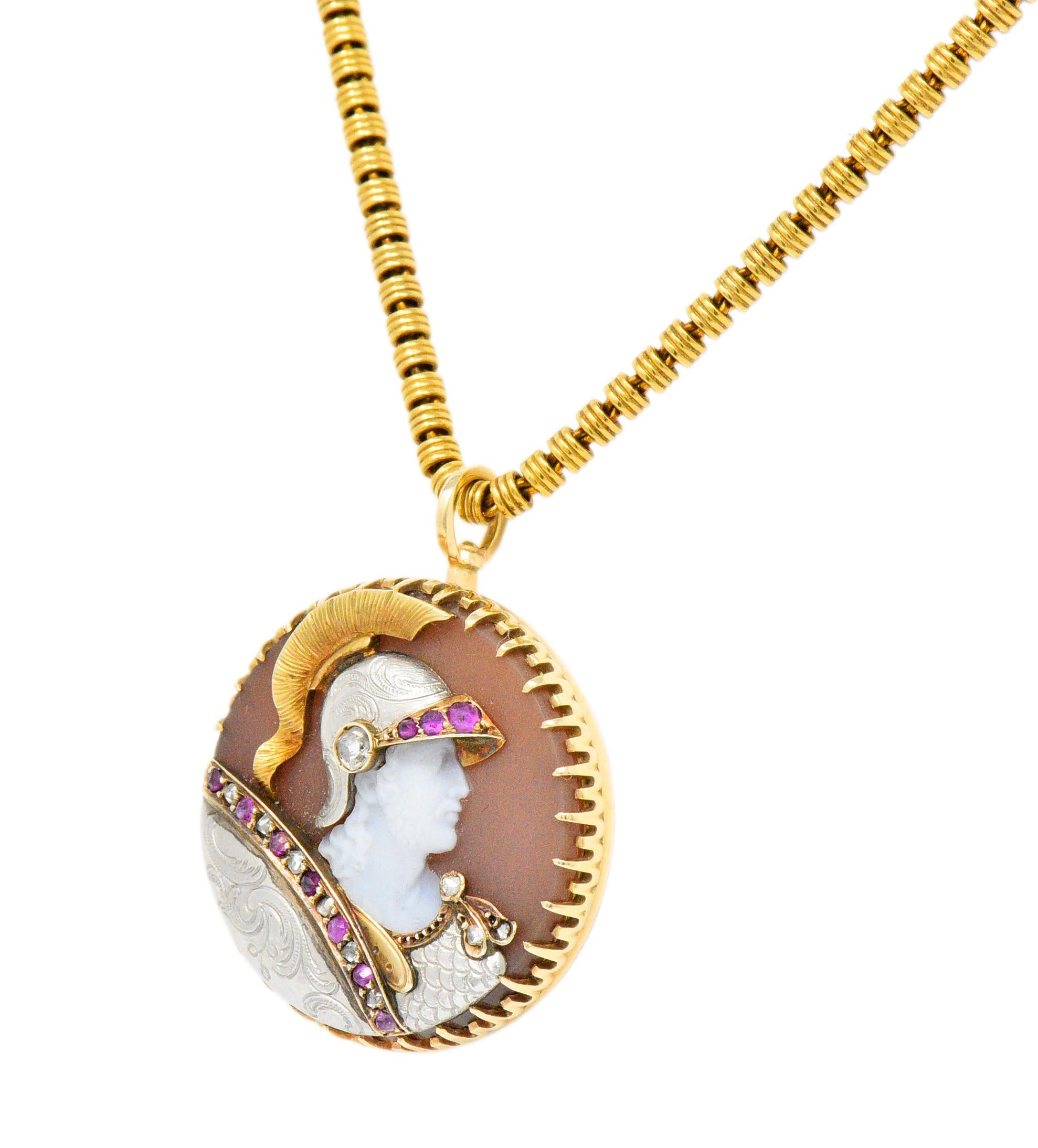 Circular pendant centers a claw set carved hardstone depicting the cameo profile of a Roman Centurion topped by a gold plumed helmet and carrying an ornate shield 

Translucent mauve background with striking white carved details

With applied gold