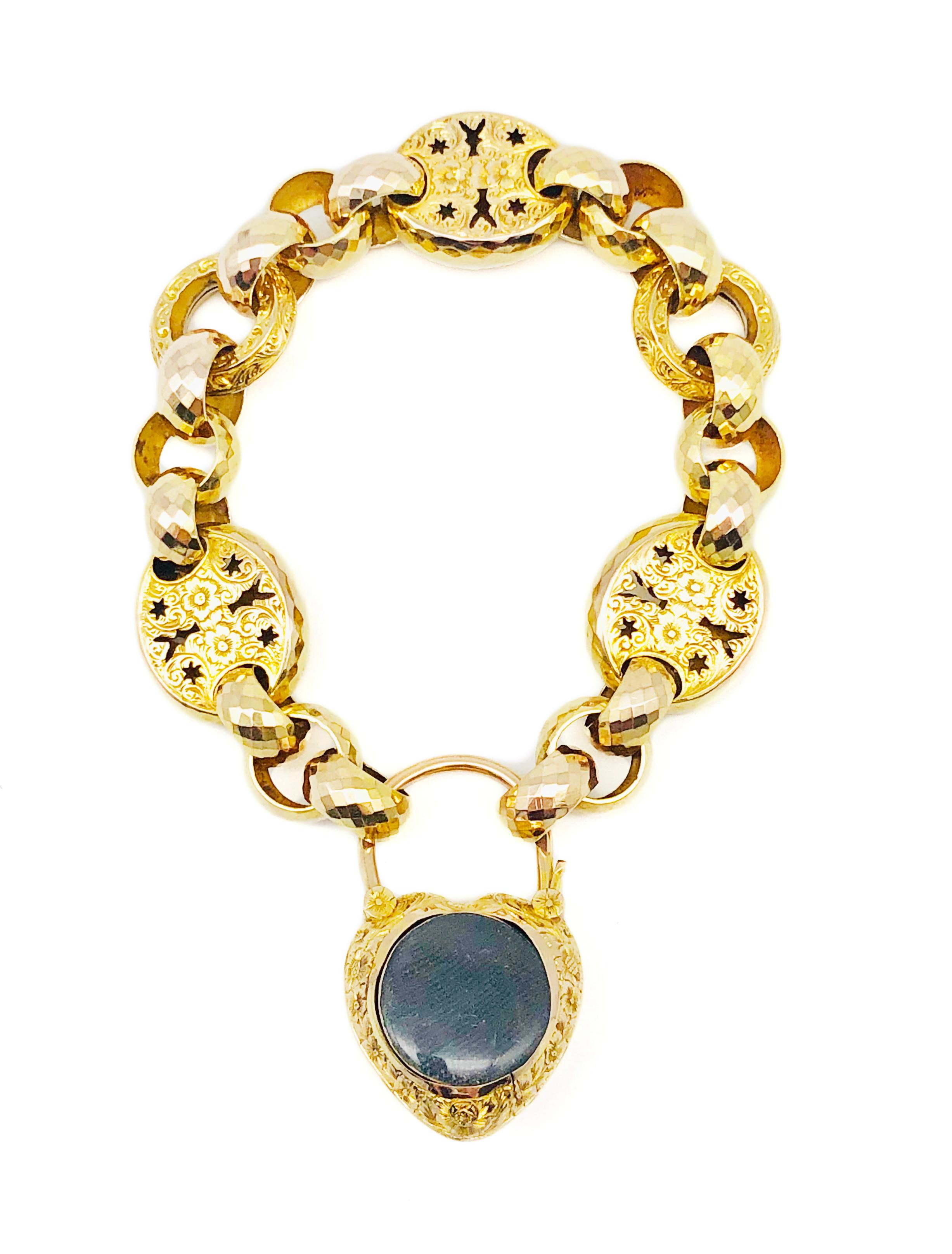 The finely engraved link bracelet with three kinds of links in two-coloured gold is held together by an engraved heart padlock with a locket back. The front of the heart is decorated with vine, vine leaves and three oval facetted aquamarines mounted
