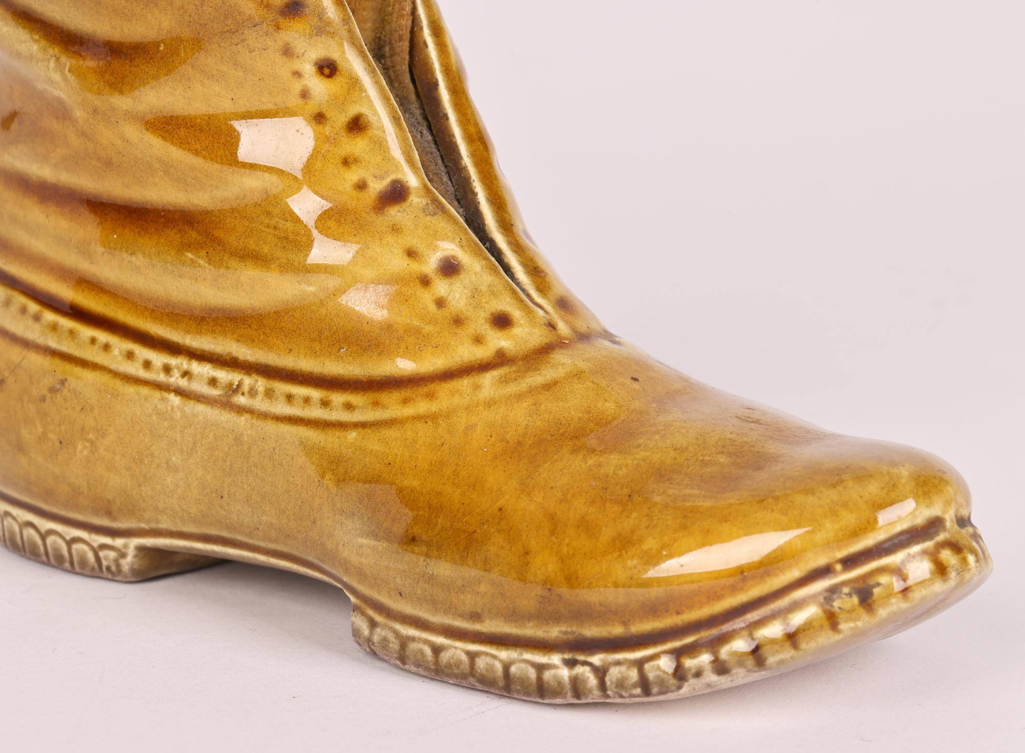 Un inhabituel et grand coussin à épingles pour bottes en poterie vernie au miel de l'époque victorienne, probablement du Staffordshire, datant du XIXe siècle. La grande botte est bien empotée, capturant les plis et le caractère du cuir, avec un