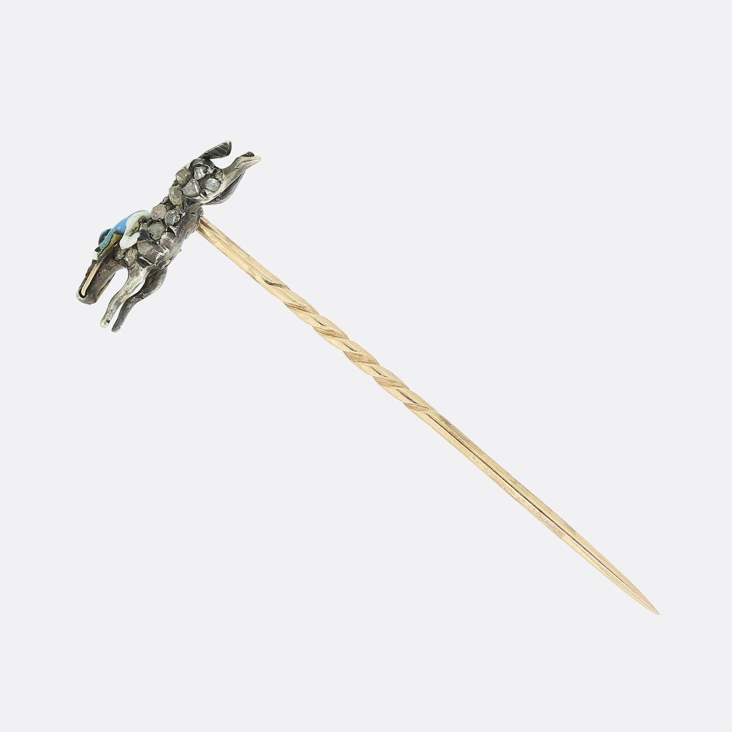 This is a Victorian 9ct yellow gold and silver stick pin. The head of the pin features an enamel jockey riding a horse which has been set with rose cut diamonds with ruby eyes. The diamonds have been set in silver and backed in gold. 

Condition: