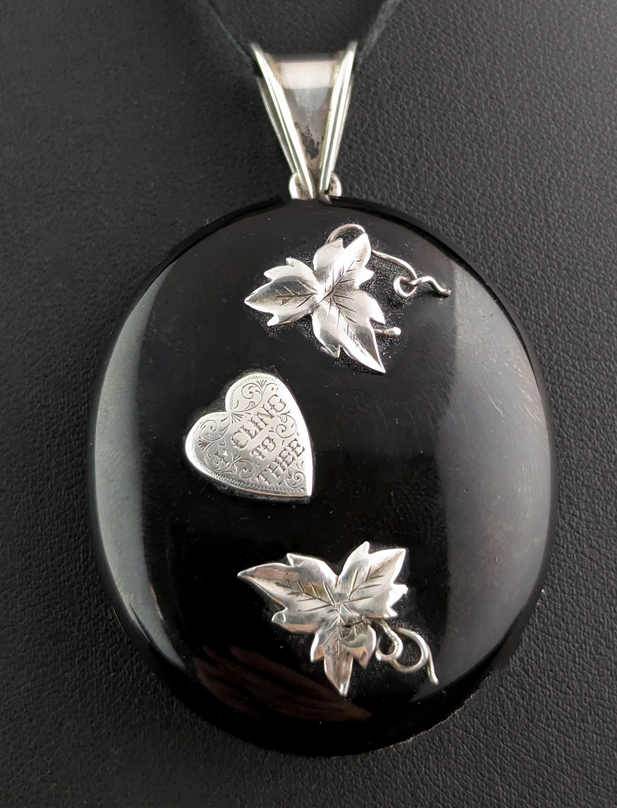This antique Victorian Whitby Jet and sterling silver locket is truly unique and incredibly beautiful.

This locket is an oval shape with a smooth polished jet front and back, mounted on a silver frame, the front has applied silver detailing of two