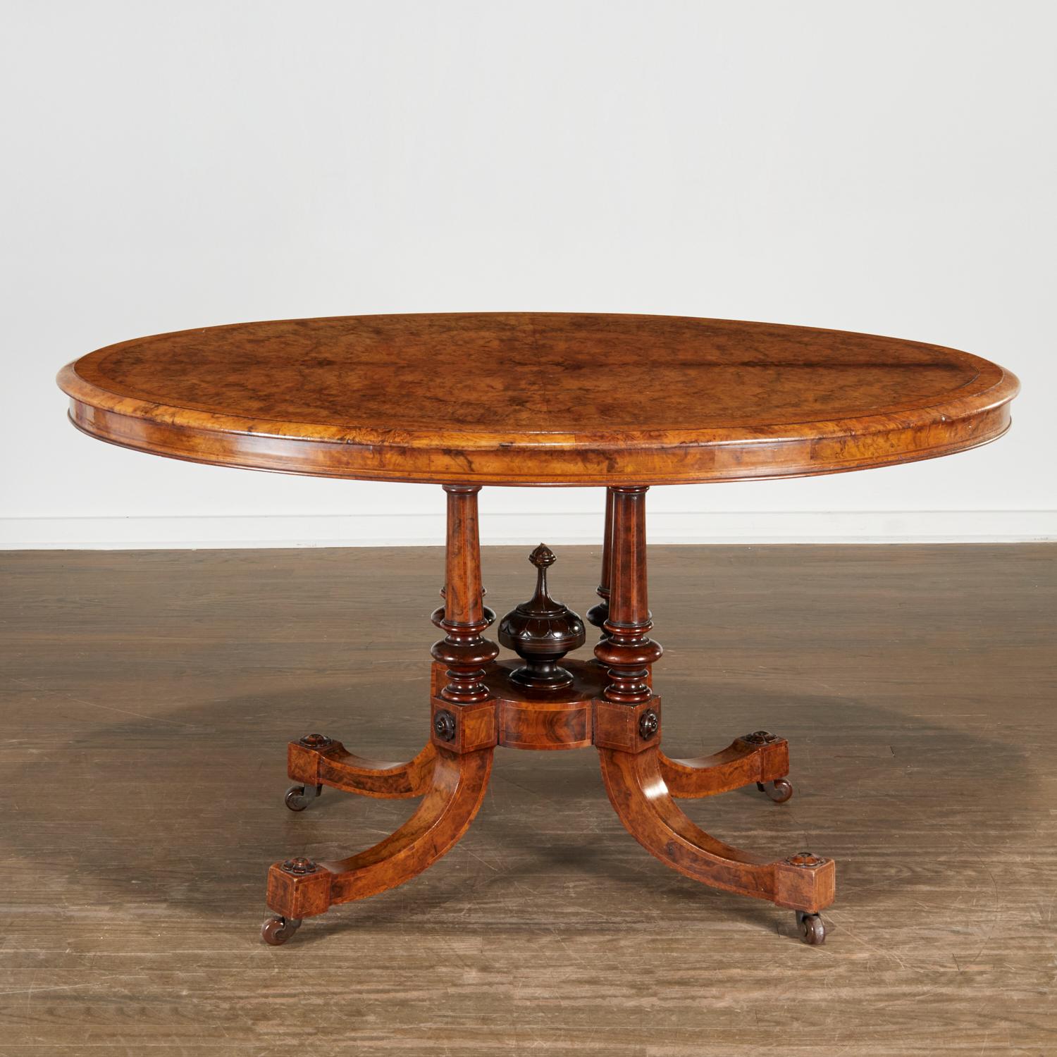 Very handsome breakfast table, 19th c., England. The oval top veneered with highly figured book matched burlwood, with burr elm banding, over four inlaid turned supports, raised on four down-swept legs applied with carved floral bosses on brass