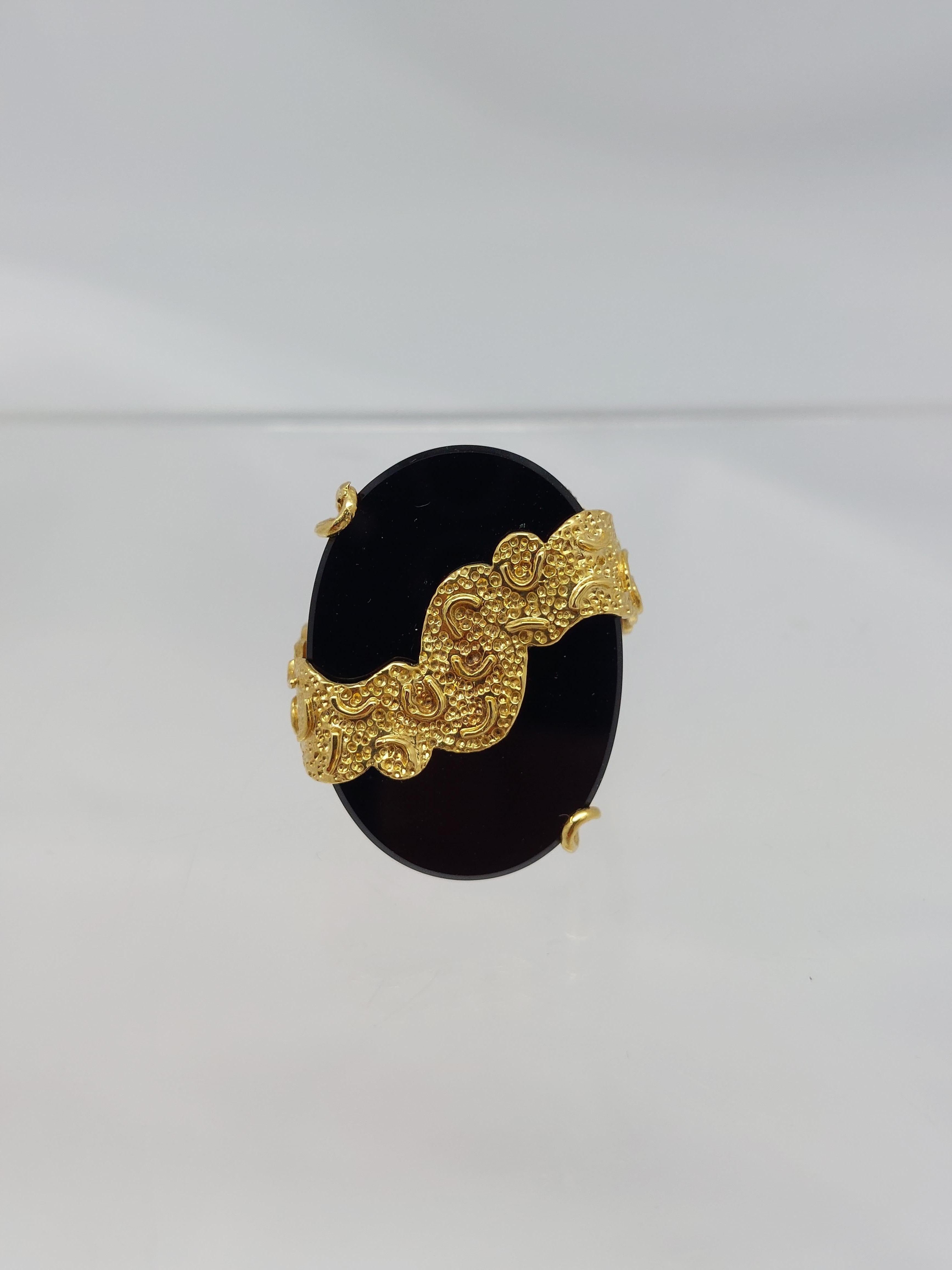 Anillo de ónice de oro amarillo de 18 quilates con detalles de 3 diamantes.
El ónice tallado en forma de pastilla ovalada mide   1″  x  3/4 