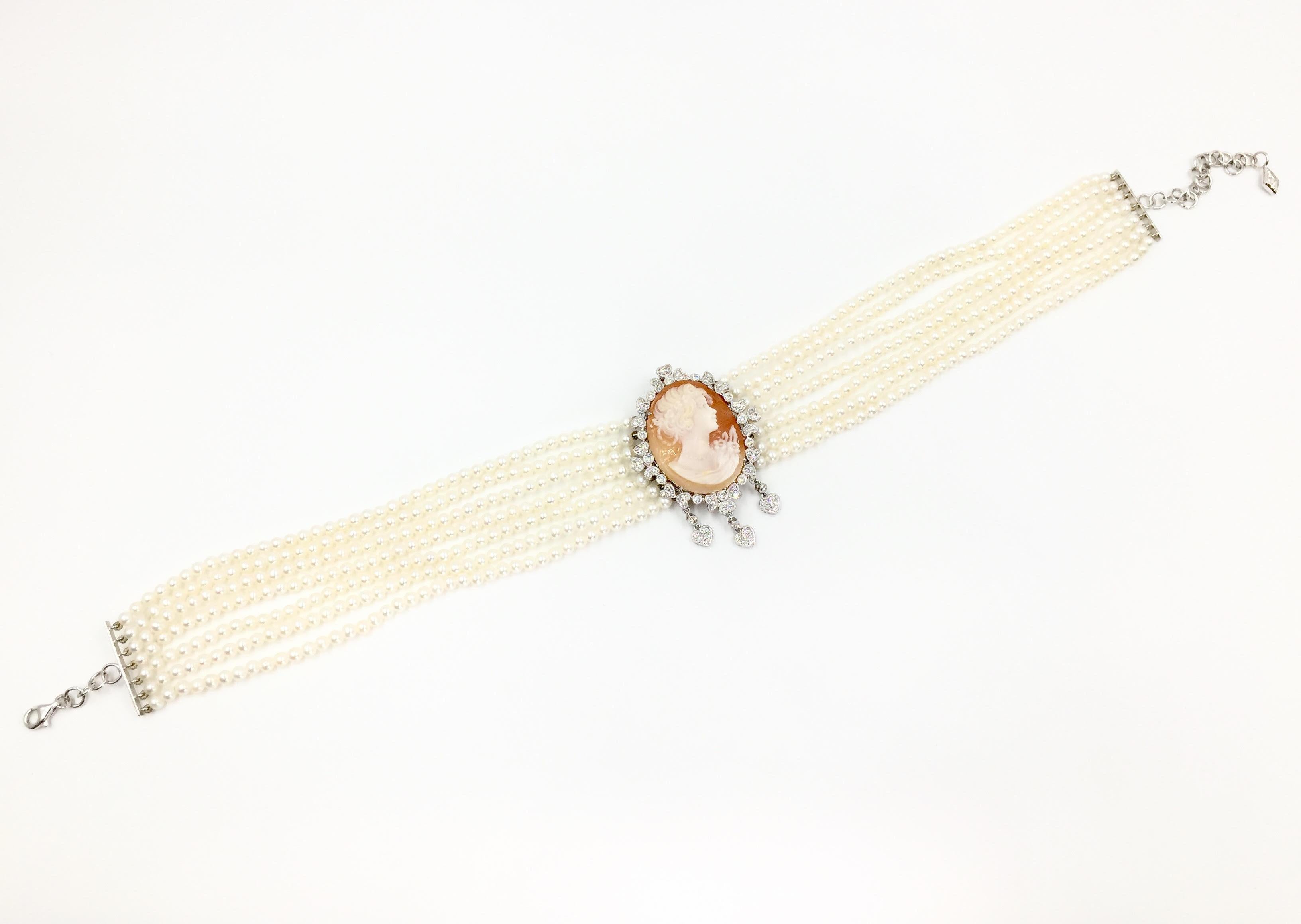 Two beautiful styles in one piece. This Victorian inspired 18 karat white gold seven strand 3.5mm seed pearl choker style cameo necklace has detachable clasps so cameo and diamond piece can be worn as a stunning pendant. The orange-peach carved