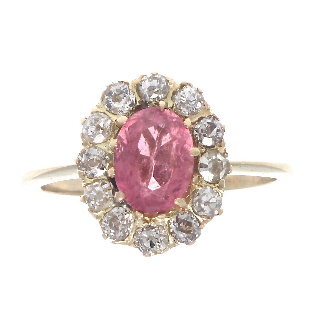 The iconic cluster design that was modeled after a blossoming daisy. Featuring a vibrant pink tourmaline that has been surrounded by petals of diamonds. Crafted in 18k yellow gold. Ring size 7-1/4 and can easily be resized, if needed this would come