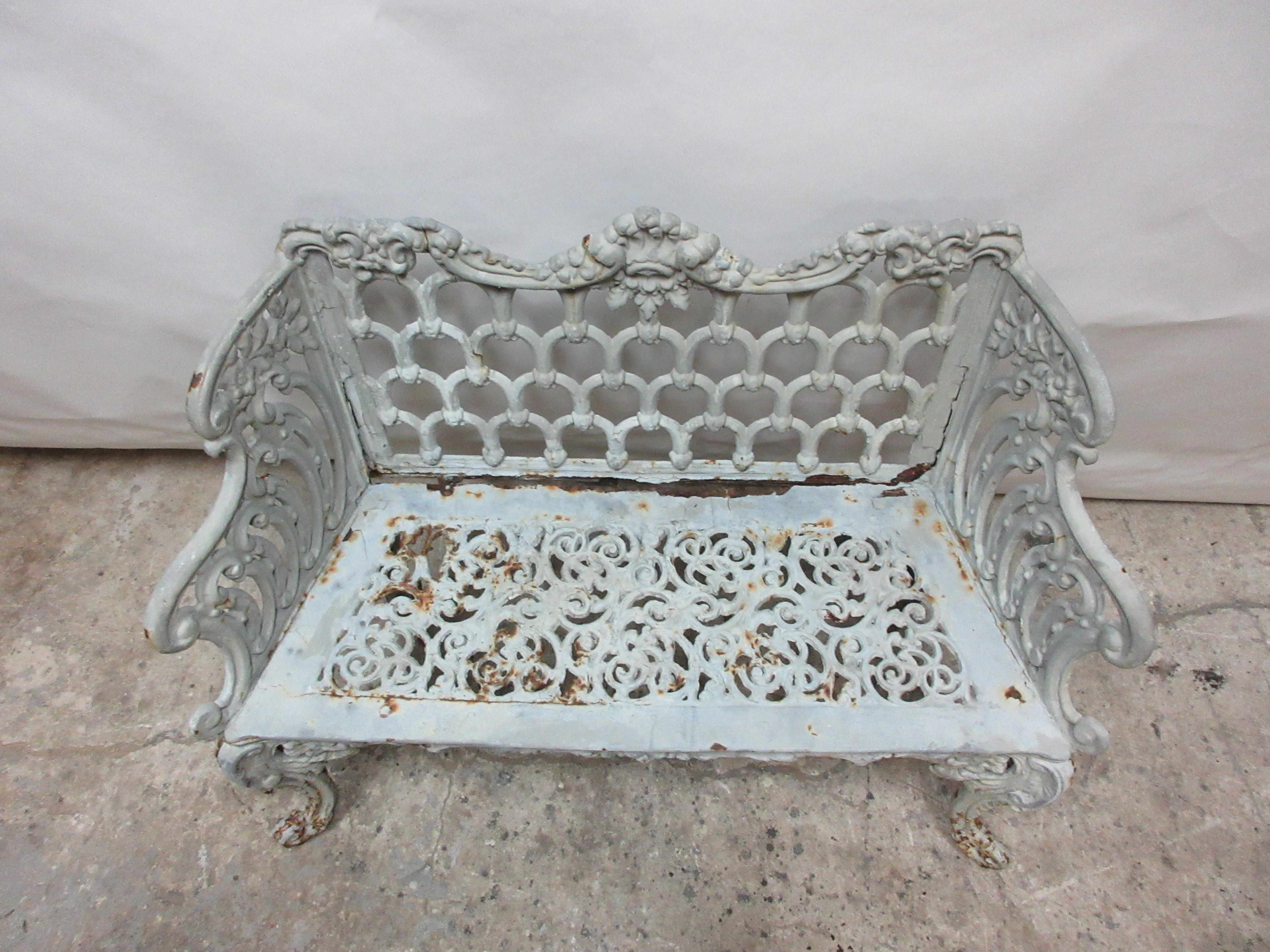 This is a Victorian iron bench, it has a very old paint on it. It has a small crack at the top left hand side of the back.