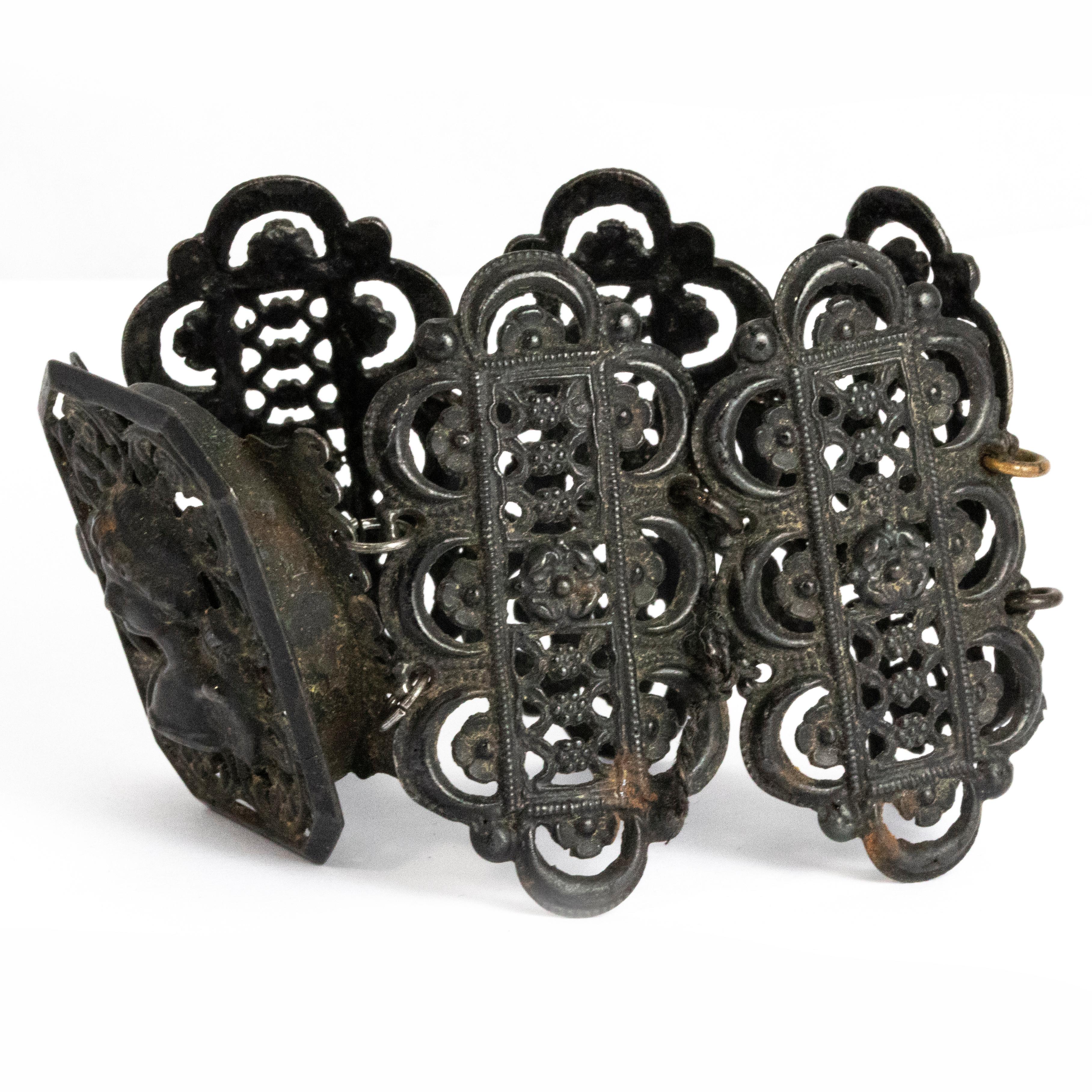 This cuff is a wonderful example of Victorian iron work. The bracelet is made up of 6 panels, one of which has the beautiful silhouette of a lady on it. The rest of the panels have delicate detail on them and all are connected by metal loops.