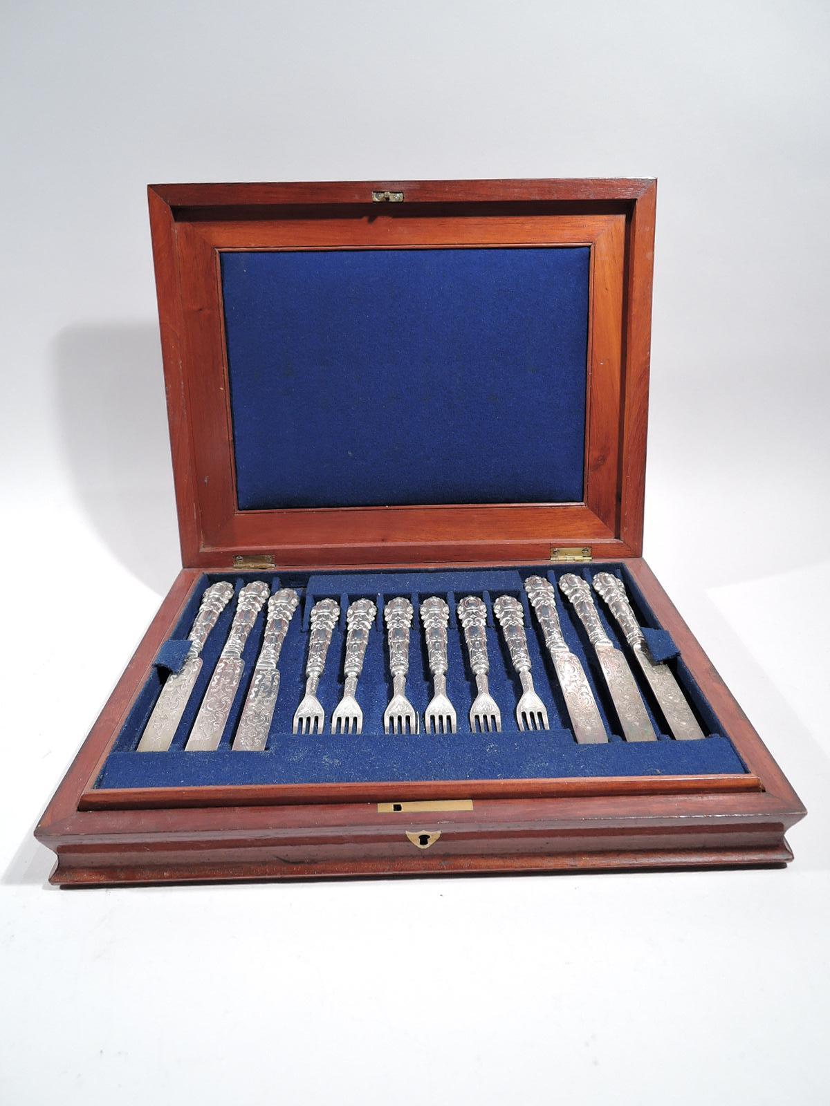Victorian sterling silver fruit set. Made by Henry Wilkinson & Co. in Sheffield in 1854. This set comprises 12 knives and 12 forks. Strapwork handle and scrolled terminal engraved with monogram. Blades and shanks engraved with same. Ramped up