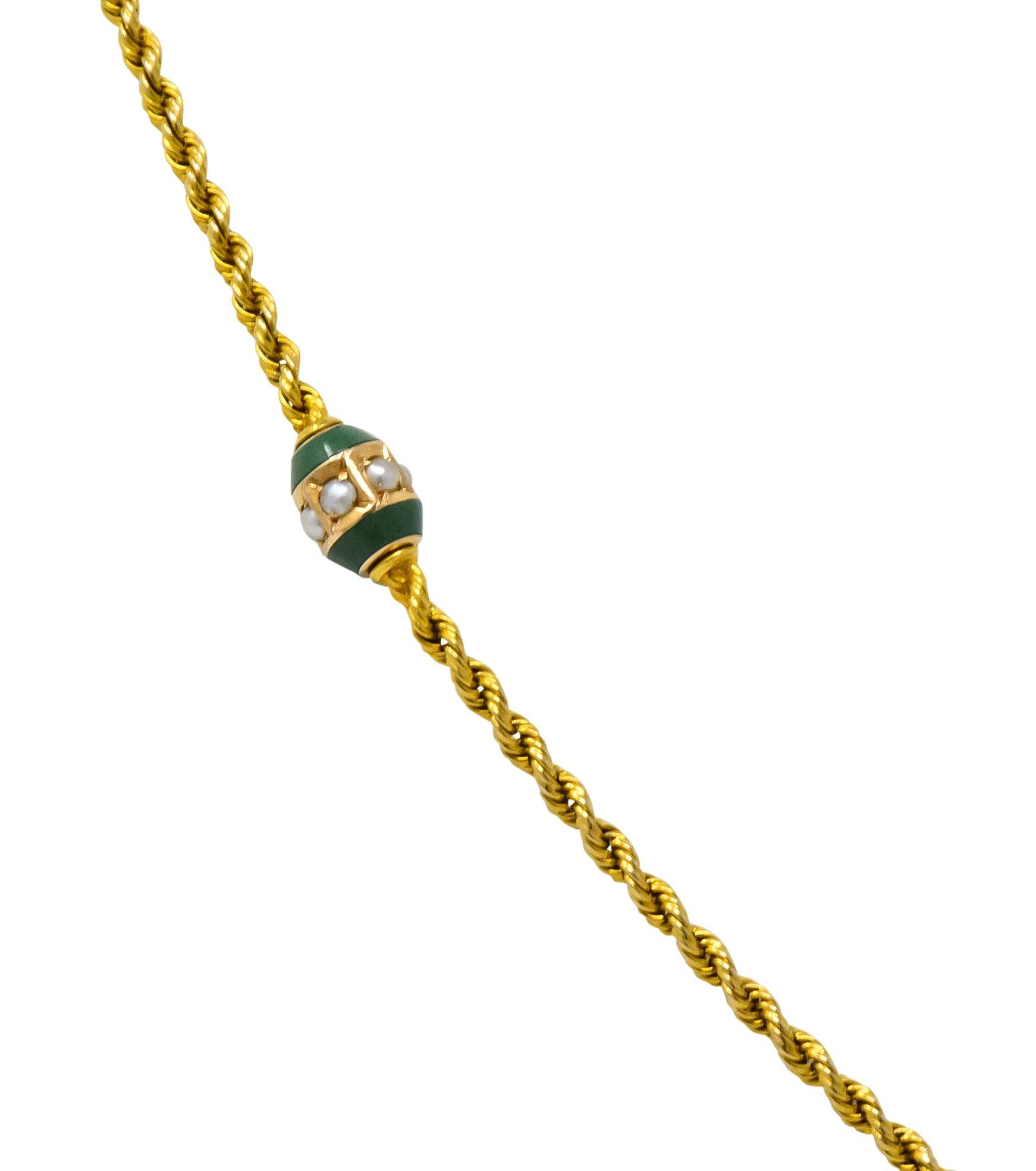 Designed as a long twisted rope chain featuring six jade capsule stations 

Each centering a gold band set with seed pearls

Completed by a spring ring clasp

Stamped 14K for 14 karat gold

Circa: 1880

Length: 48 1/2 inches

Width at widest: 4.0