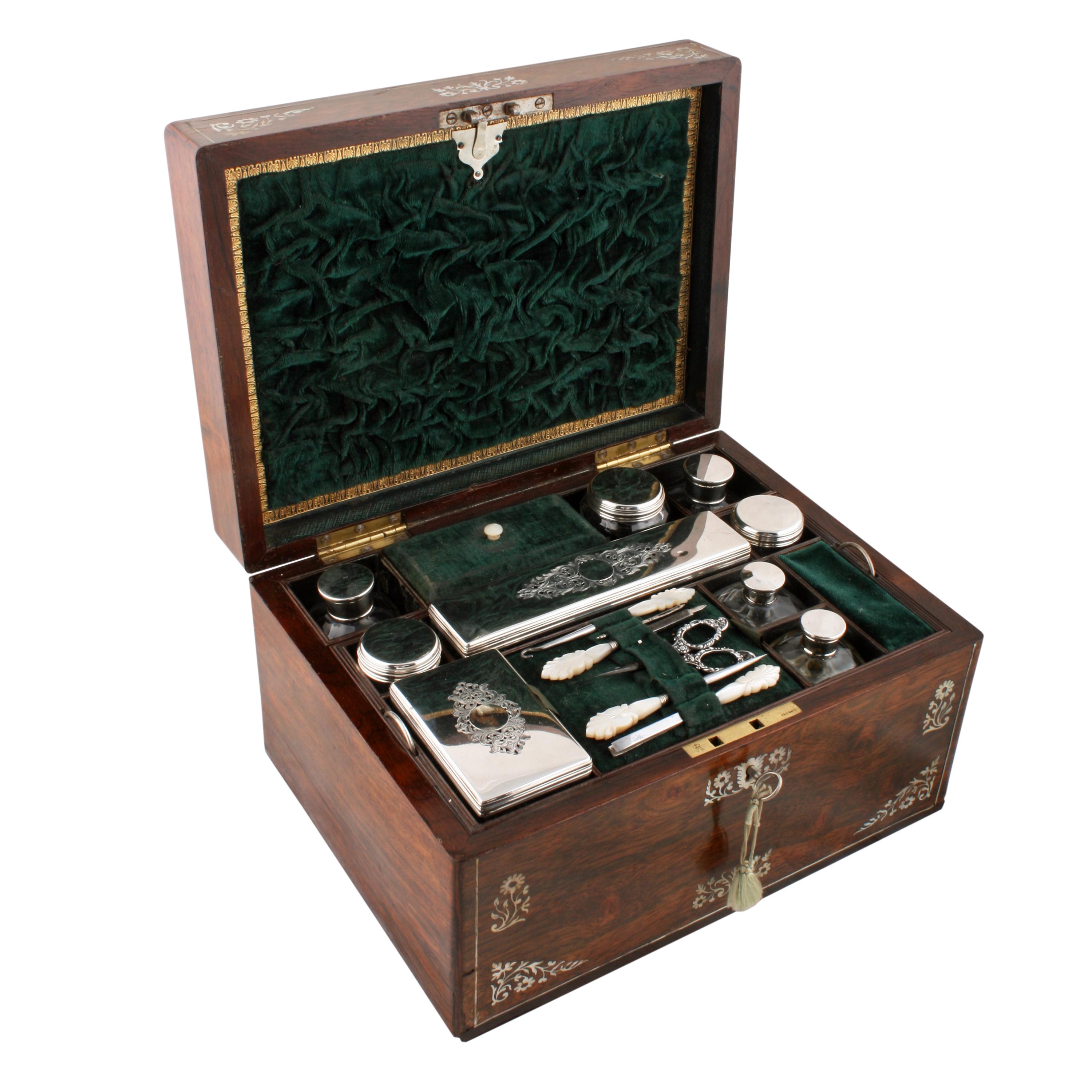 Victorian jewelry dressing box.


A mid-19th century Victorian rosewood jewelry or dressing box.

The box is inlaid with mother of pearl and pewter and has a side drawer to hold jewellery.

The interior has several jars and bottles with