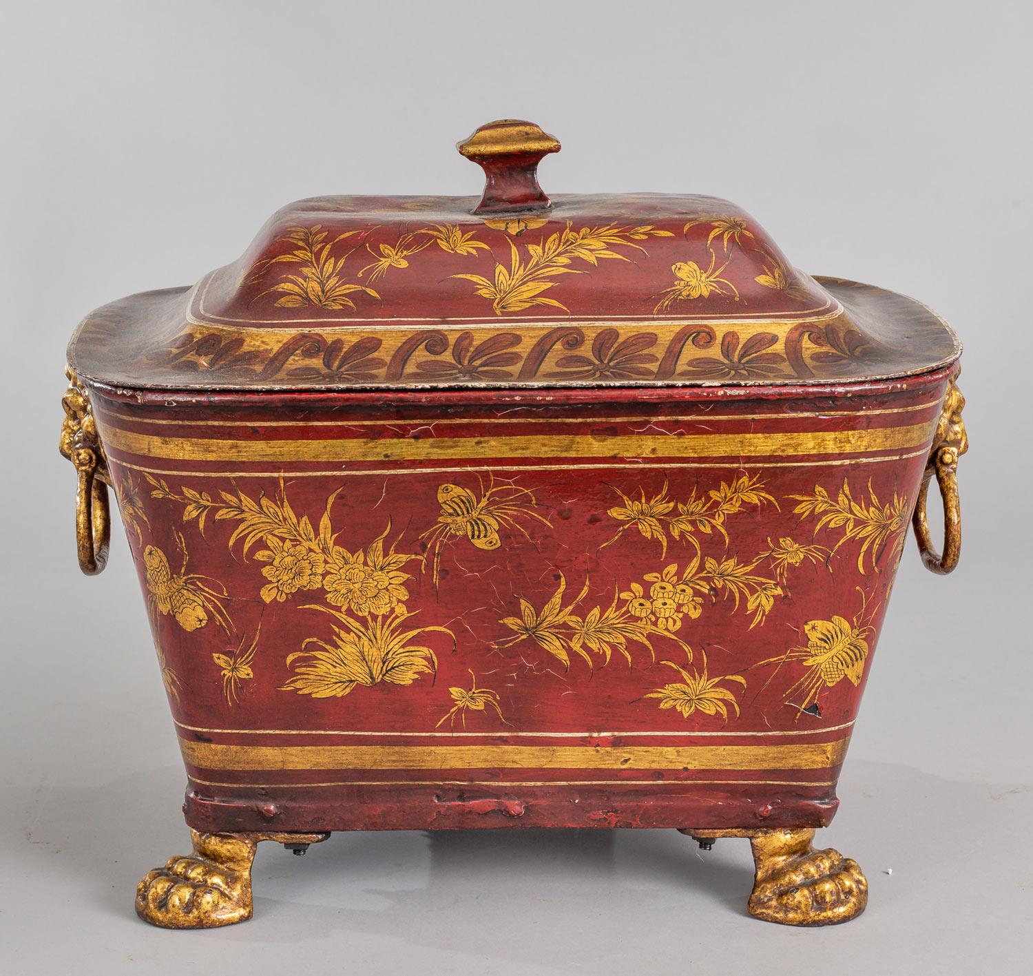 Early Victorian rectangular lacquered tole coal bucket with lion’s mask and ring handles, the body and lid decorated with gilded foliage, butterflies and insects on an iron red background, mounted on gilded lion’s paw feet.