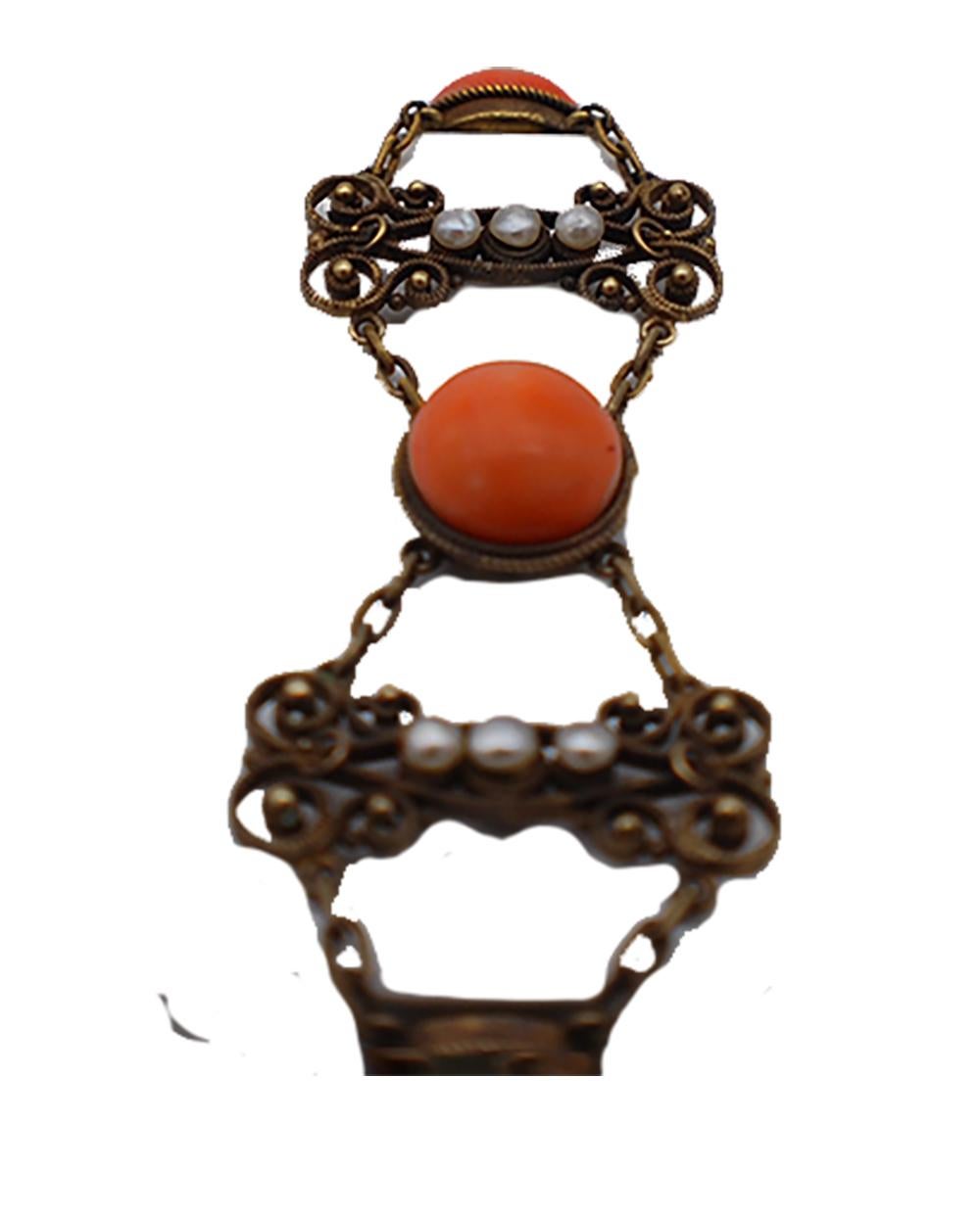 Victorian, Gold filigree style bracelet consists of 4- coral gemstones measuring 11.58 mm each and set in etched bezels. The filigree links are seperated with chain linking 3- seed pearls that measure 2.50-3.20 mm each. The end clasp feature is a