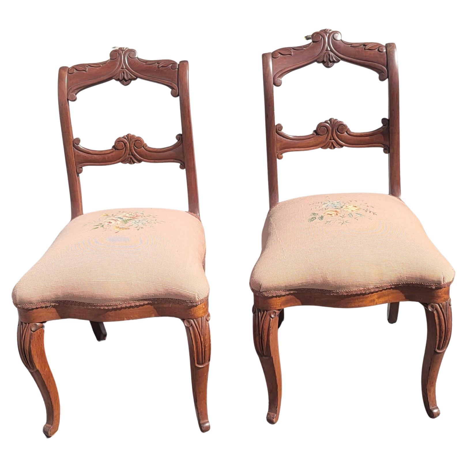 An exquisite pair of finely carved Mahogany Ladder Back victorian chairs with needlepoint seats in great condition. Seats are very firm and very comfortable. Use them as  extra seats in your dining room or else where in your home. Measures 18