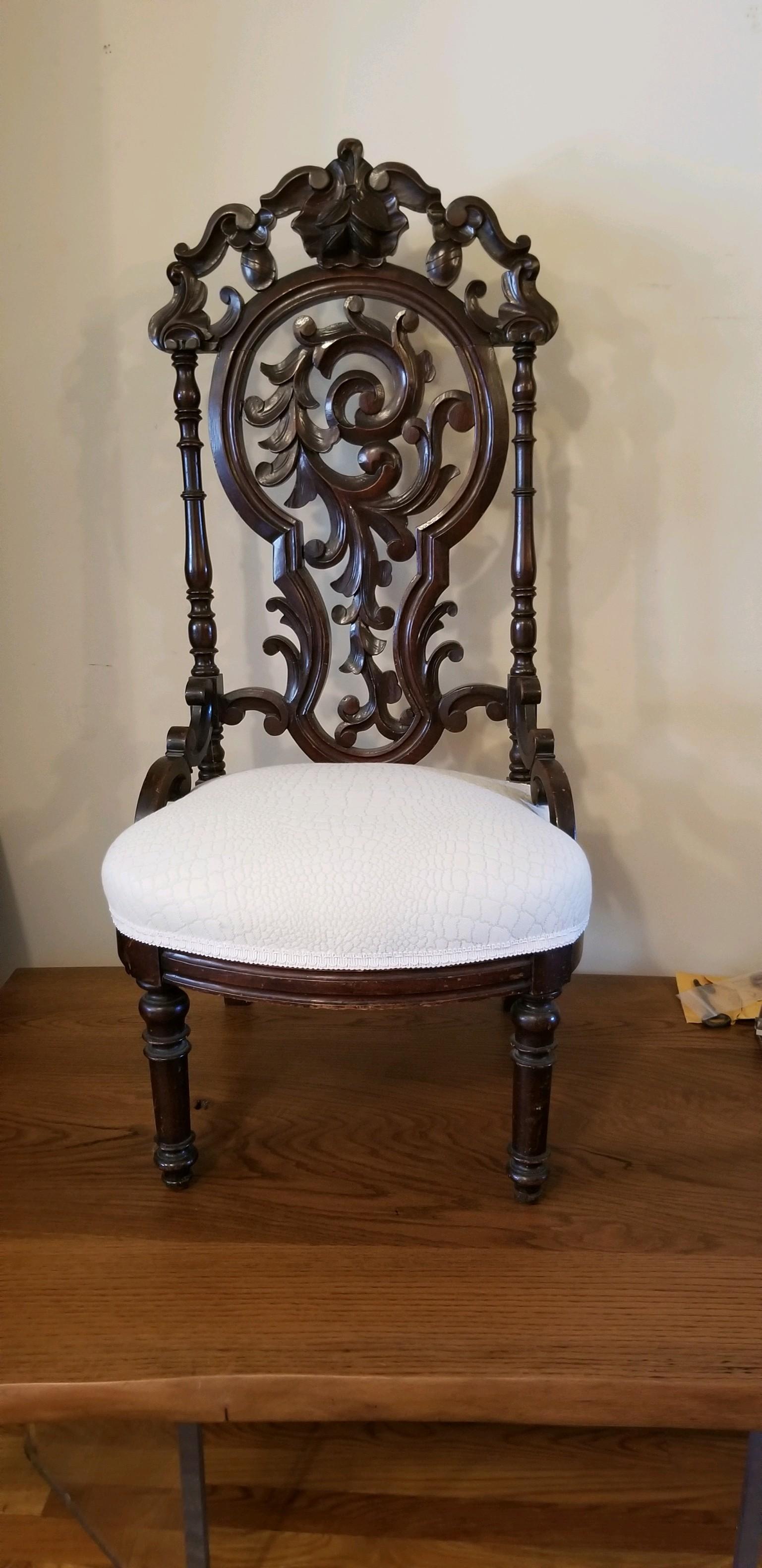 A wonderfully carved Victorian ladies chair in the style of Belter. Seat covered in alligator woven cotton. Off white in color. I use these chairs as sculpture in a room. Extreme in proportion and character. It adds a layered quality to any