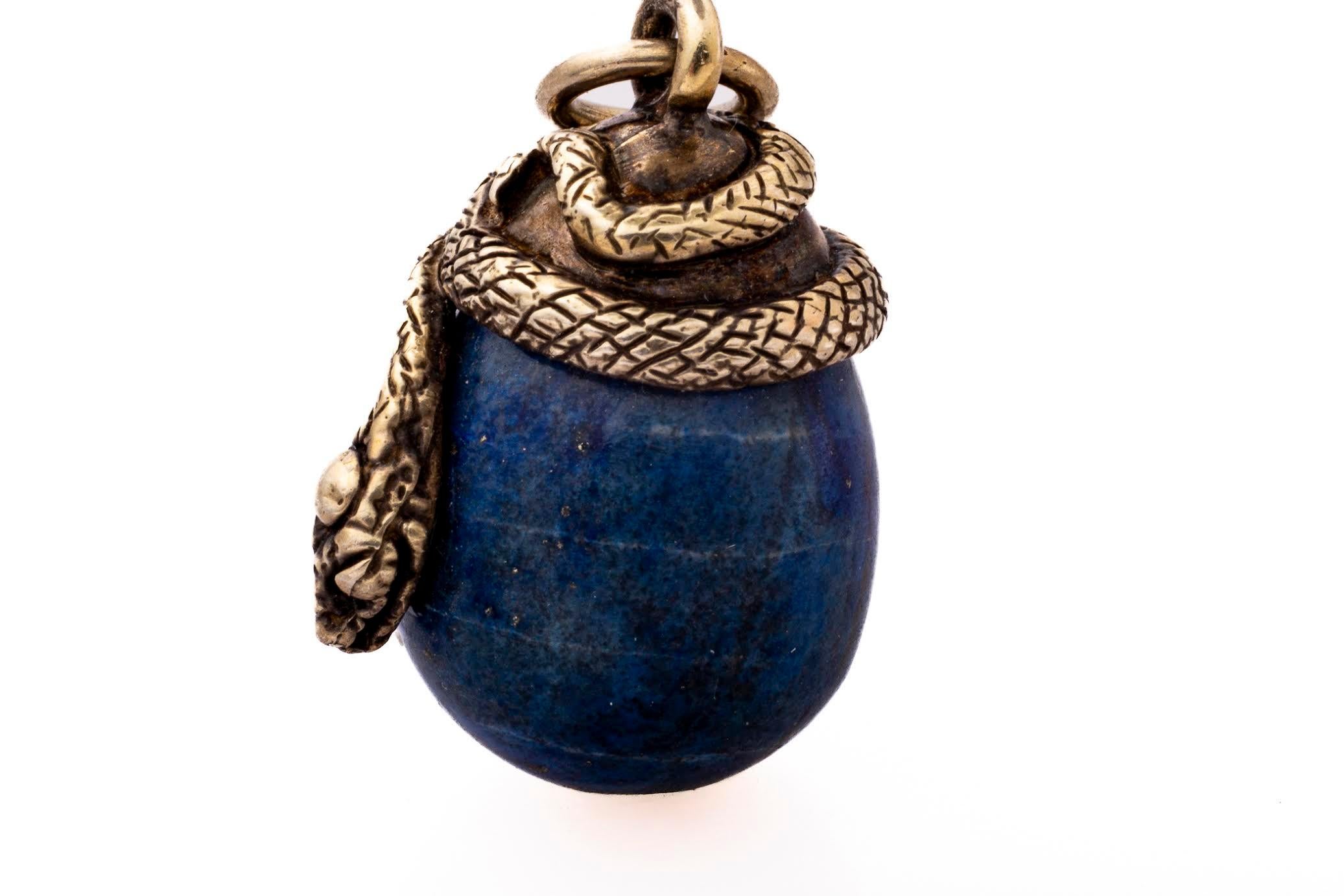 Perché c'è un serpente su questo uovo di lapislazzuli dell'epoca vittoriana? Nella gioielleria antica c'era simbolismo ovunque. Questo ciondolo è chiamato Uovo Orfico. Il serpente intrecciato sull'uovo rappresenta la forza della vita. Ha anche