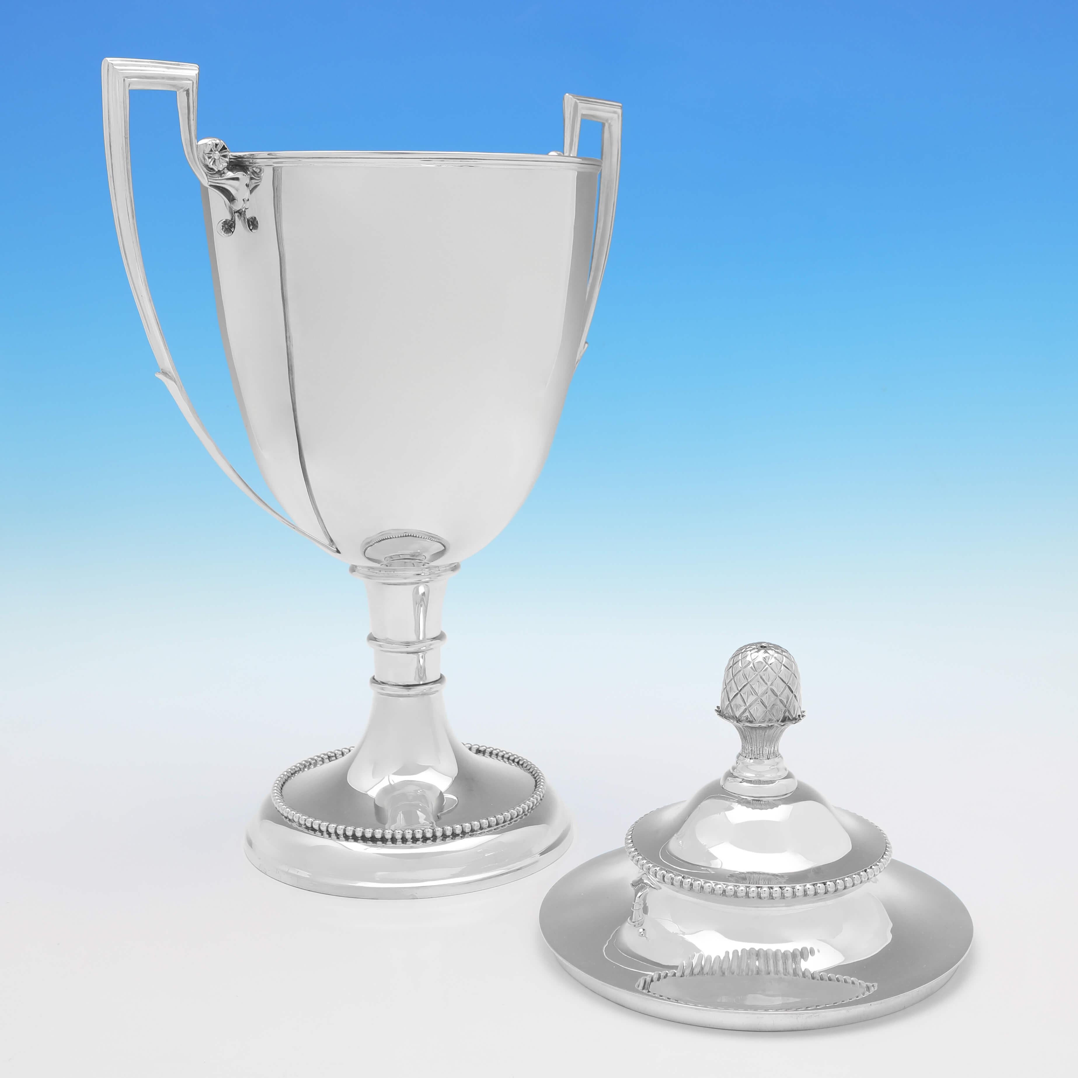 Poinçonné à Sheffield en 1898 par Alexander Clark, ce très beau trophée ancien en argent est de style néoclassique, avec des bordures en perles et un fleuron en forme d'ananas sur le couvercle amovible. 

Le trophée mesure 19,5