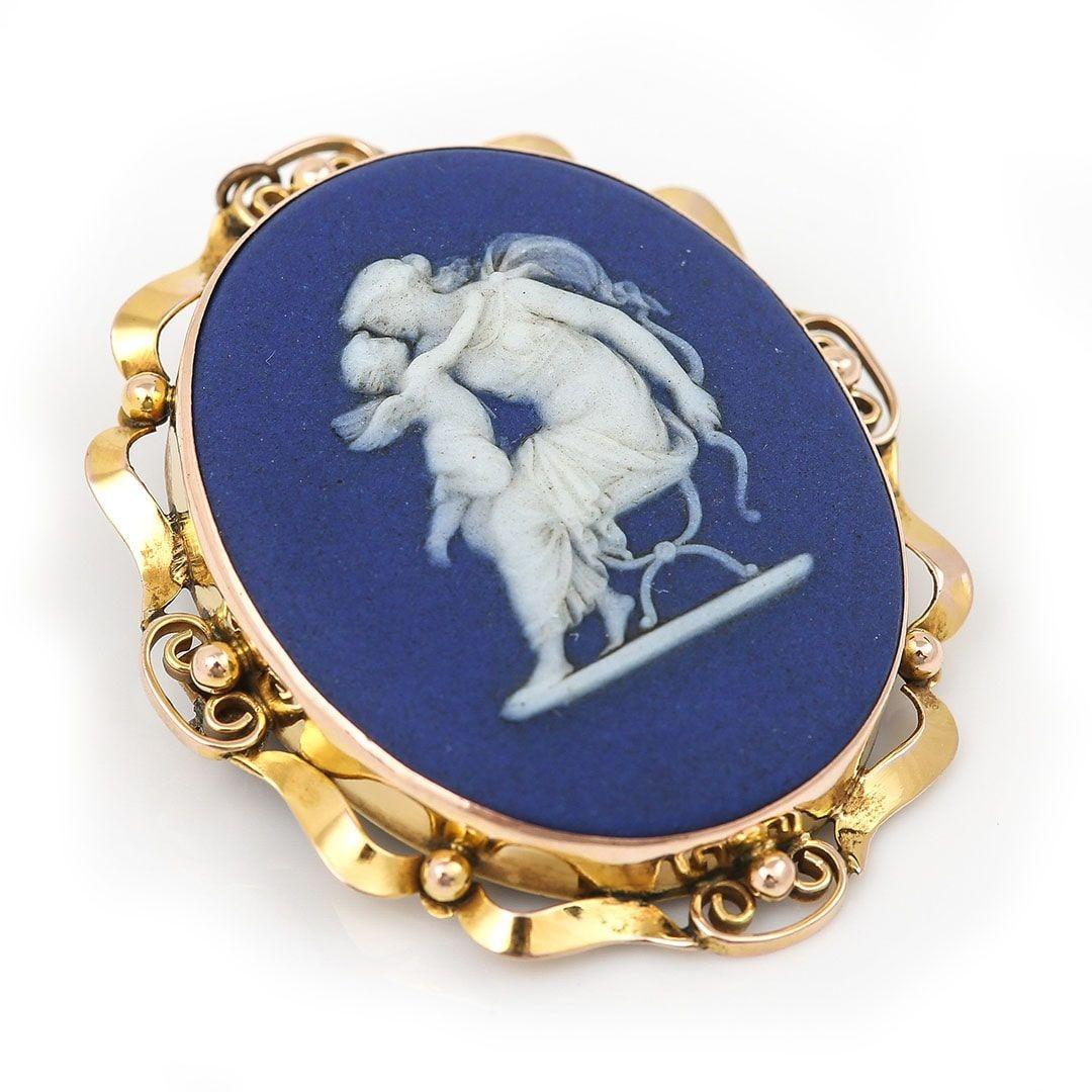 A wonderful, large oval Victorian blue Wedgwood jasper ware brooch set in 9ct gold depicting Diana kissing Cupid. The 45mm long brooch dating from the 19th century has retained its wonderful royal blue colour with the white carving showing the