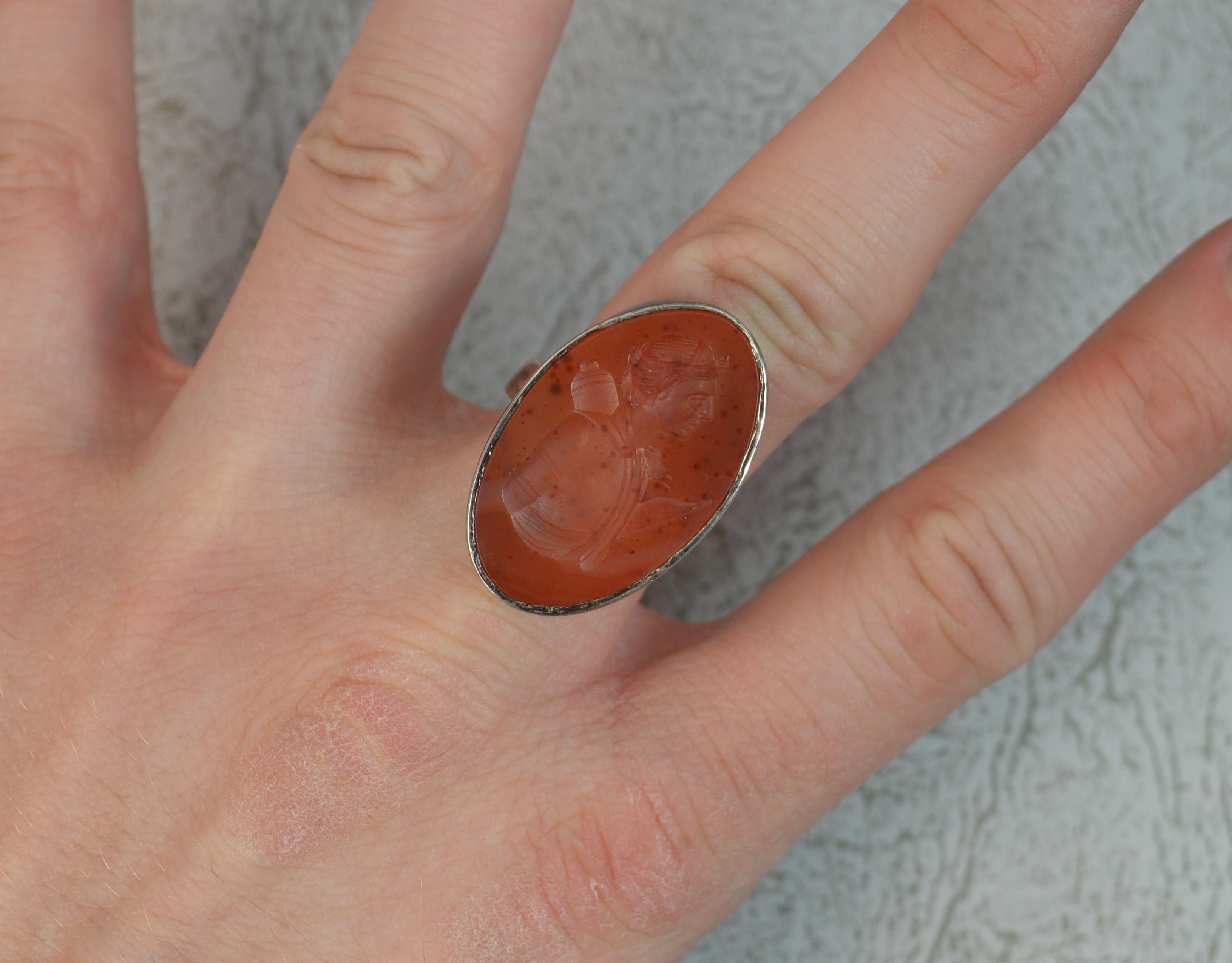 An impressive antique seal signet ring.
Sterling silver example. 
Closed bezel set carnelian agate. Finely engraved with the bust of a female archer.
Georgian or early Victorian intaglio reset circa 1900.
18mm x 29mm stone.
Hallmarks ; none, tests