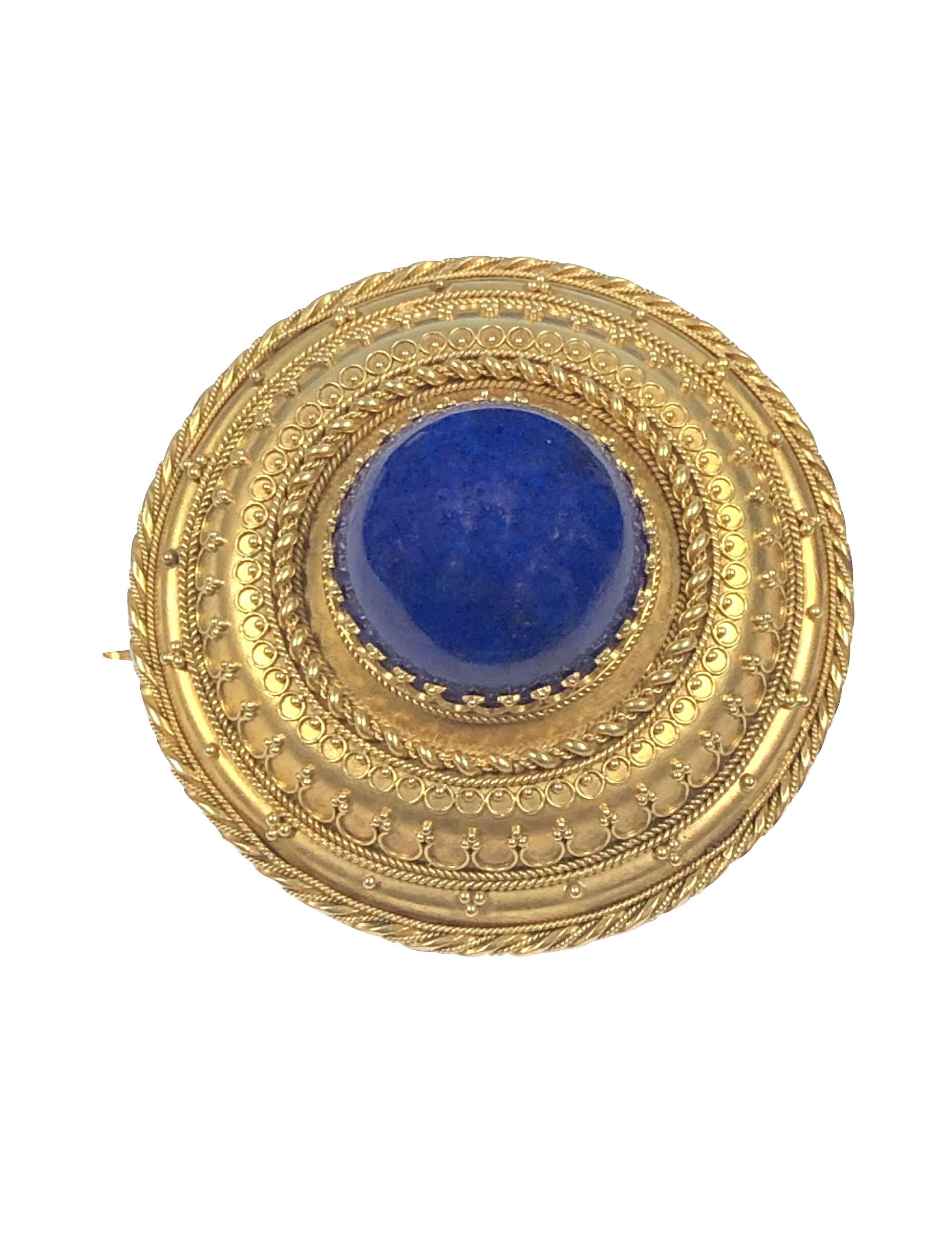 Circa 1880s Etruscan Revival Brooch, 14K Yellow Gold and measuring 1 3/4 inches in diameter and 3/4 inch in thickness. Centrally set with an 18 M.M. diameter domed Lapis Lazulli, The entire Brooch is finished in all intricate handmade Granulation