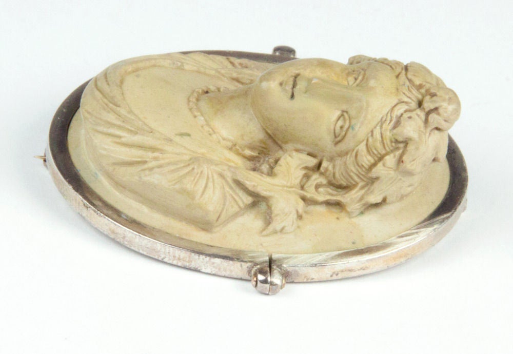 This gorgeous hand carved in High Relief Antique Lava Cameo depicts a LAVISH LADY. Incredible depth of the relief and fine detailing grapes leaves twisted through her hair, dropping to her shoulders, draped with a shawl and a stand of beads around
