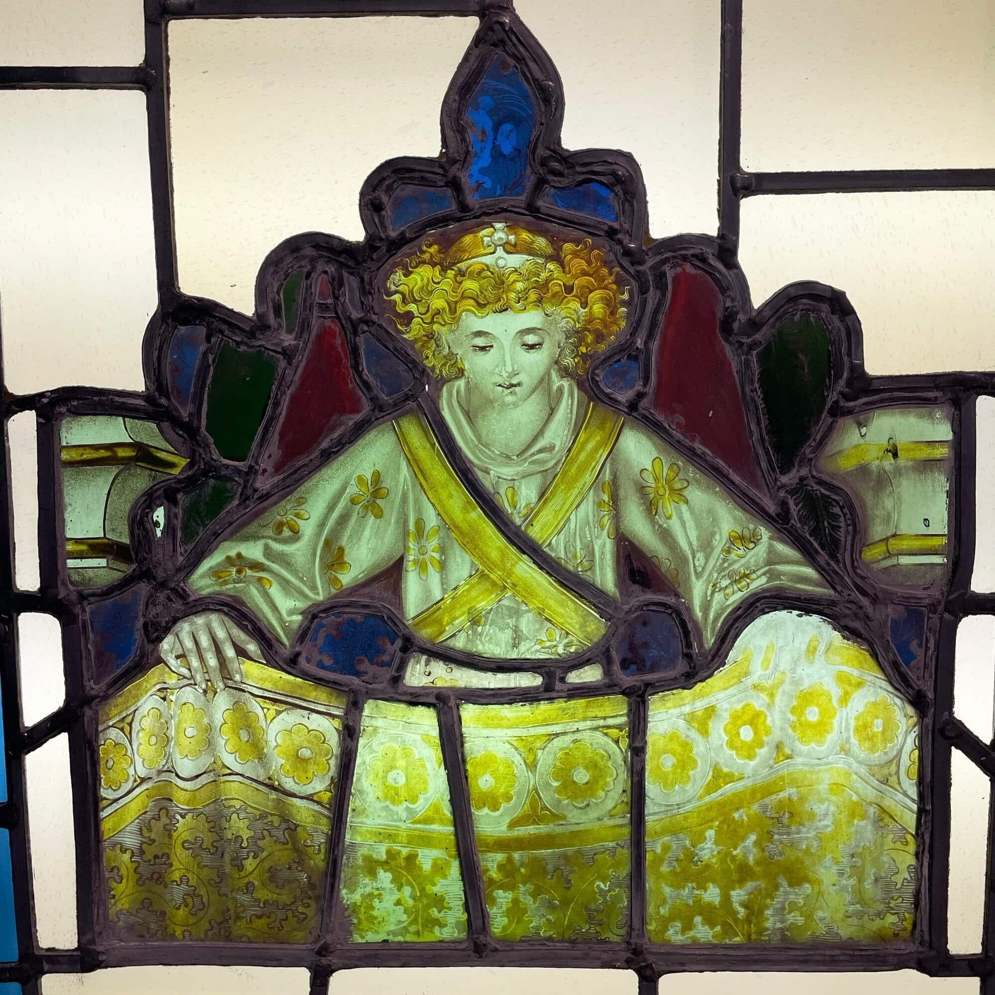 An antique Victorian stained glass window, the original centre panel of which dates to circa 1830. Later set within a frame in the mid 20th century to create a larger display piece.

This unusual antique window depicts a young boy dressed in yellow