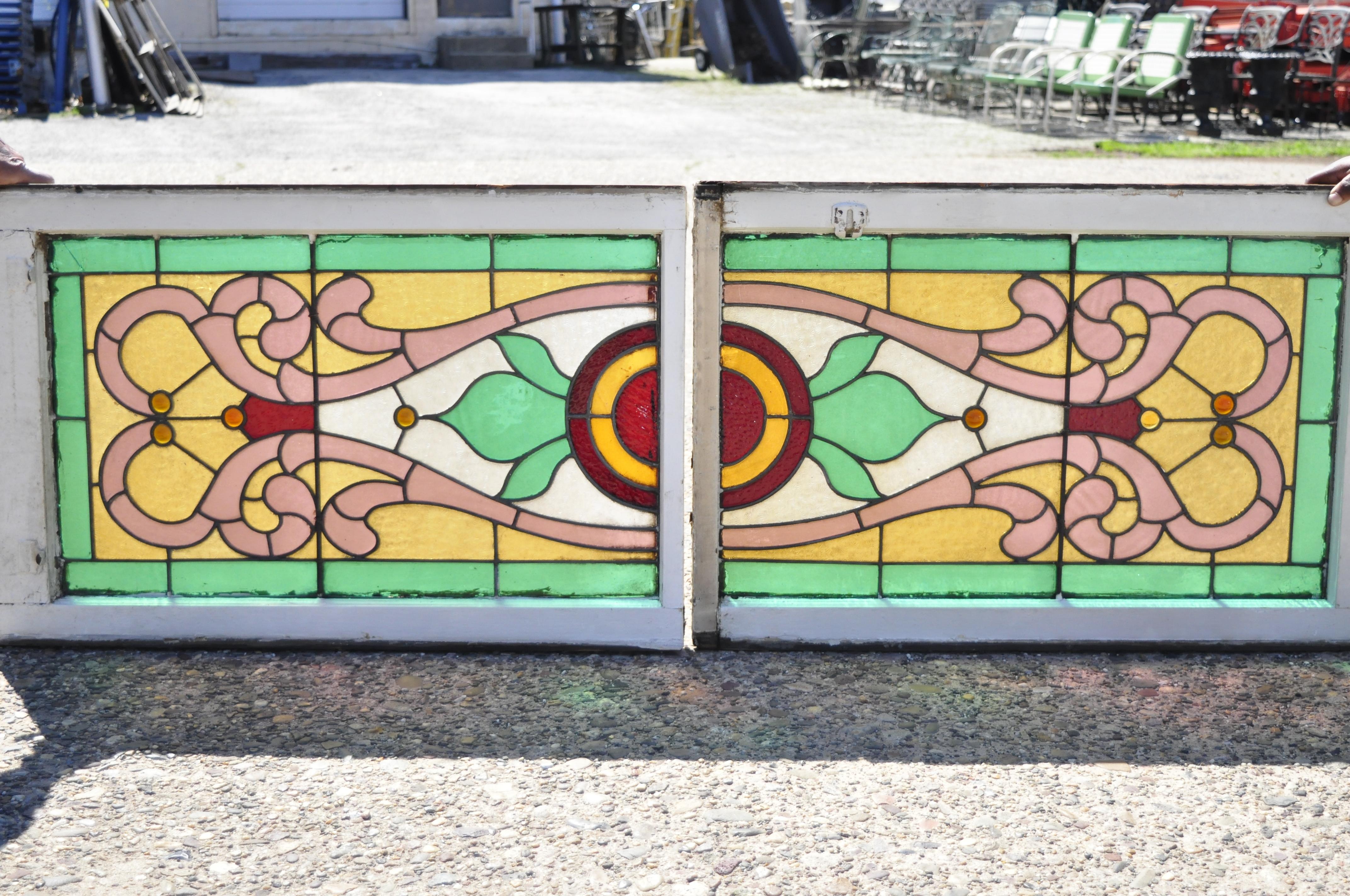 Antique Victorian leaded stained glass pink green red orange windows with jewels, a pair. Item features green stained glass border, multi-color scrolling design, 4 orange 