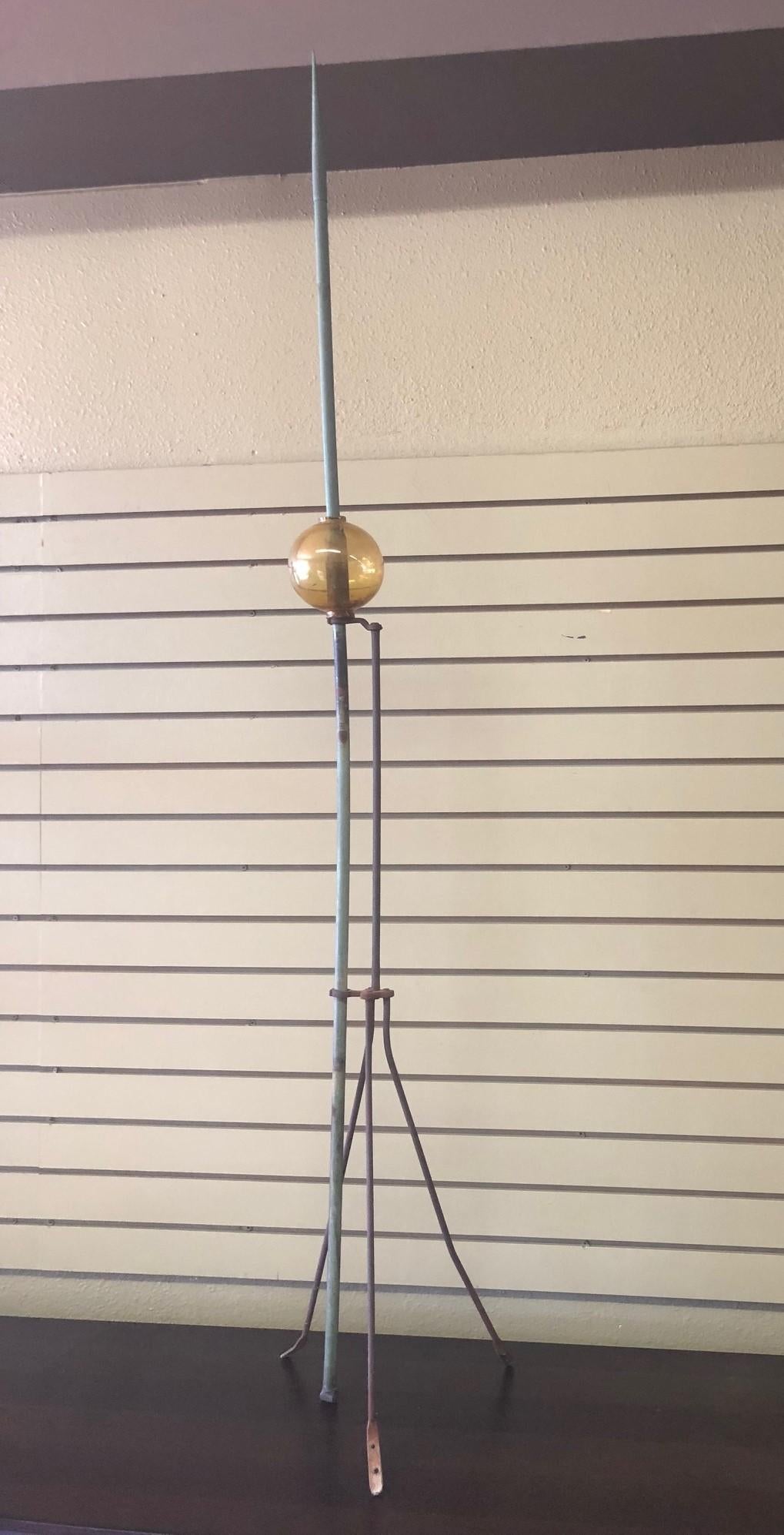 A very nice Victorian lightning rod made of a wrought iron tripod base and a slender copper rod pole with original glass ball, circa 1920s. The piece is in good vintage condition with beautiful verdigris patina on the rod.