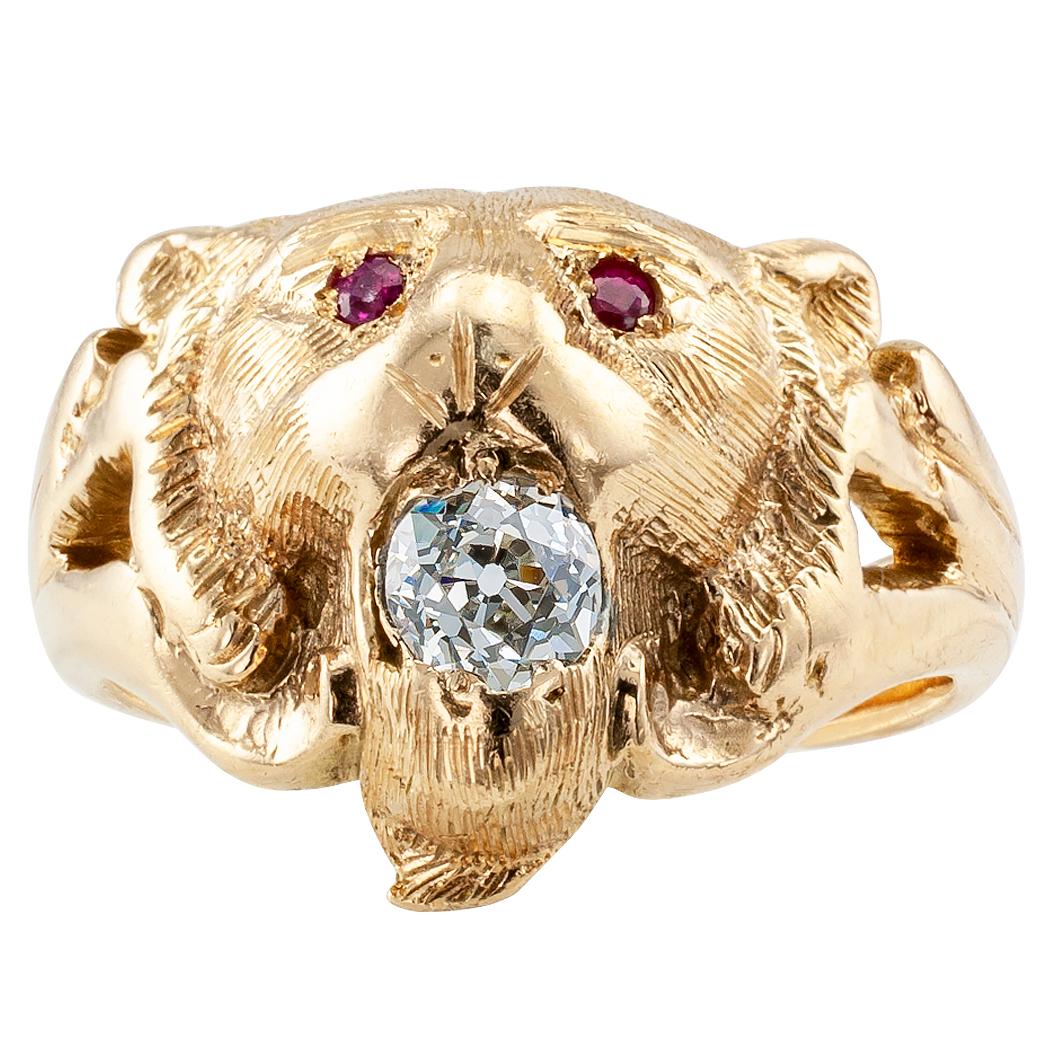 Victorian unisex lion head gold ring with rubies and diamond circa 1890. Designed as a lion head with ruby-set eyes and an old mine-cut diamond within the grip of its fangs, the diamond weighing approximately 0.35 carat, hand engraved details over