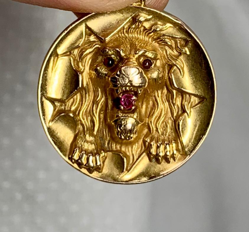 Se trata de un fabuloso colgante que representa a un León irrumpiendo a través de un aro de Circo.  El Colgante Victoriano es de Oro de 14 Kilates con ojos y boca de Rubí.  Éste es uno de los colgantes antiguos más maravillosos de la Belle Epoque