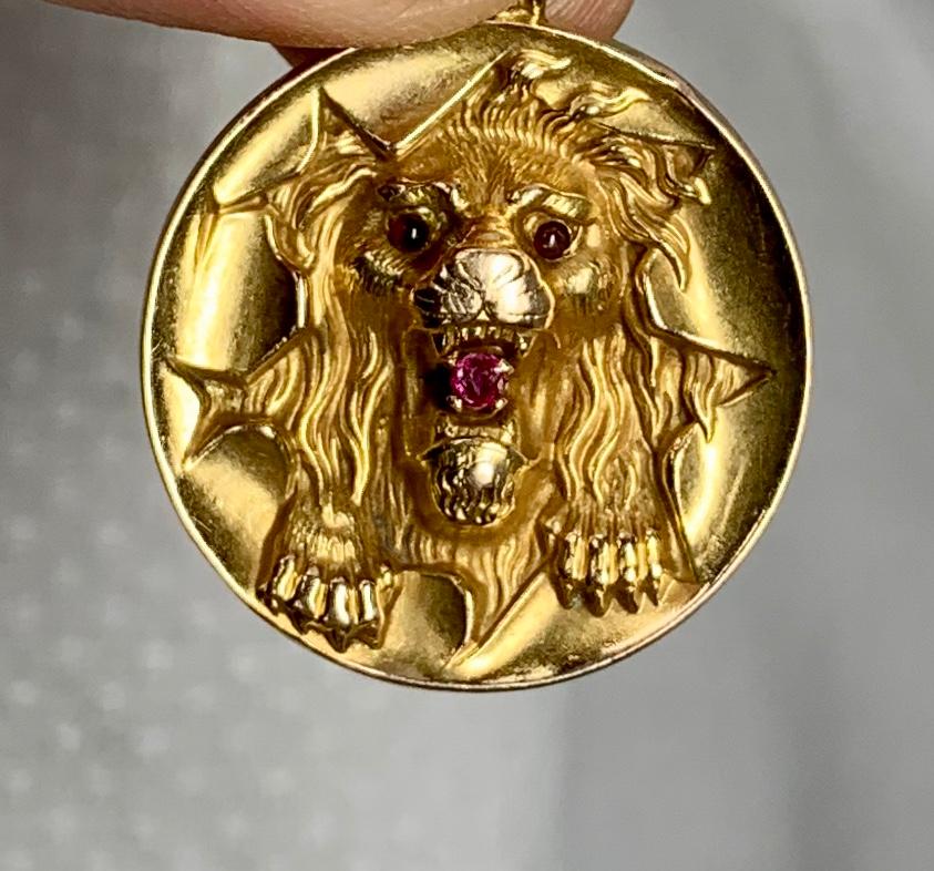 This is a fabulous pendant depicting a Lion bursting through a Circus hoop.  The Victorian Pendant is 14 Karat Gold with Ruby eyes and mouth.  This is one of the most wonderful antique Belle Epoque, Victorian pendants with a beautifully modeled