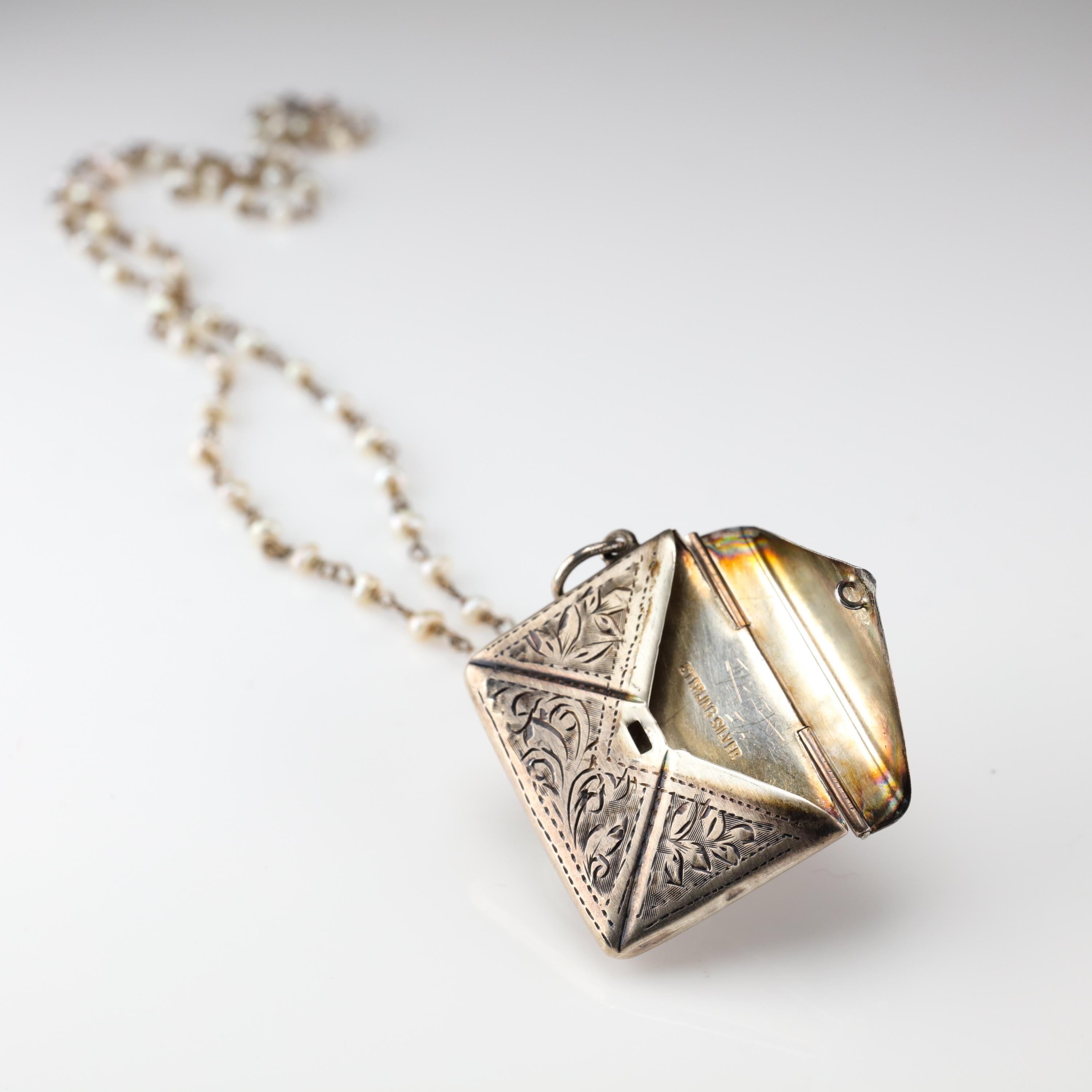 This handmade Victorian-era envelope locket pendant features a flap that unclicks with your fingernail, lifts up and reveals a 29 mm long, 19 mm tall envelope pocket with an internal depth of 3.54 mm,  into which you could store several micro USB