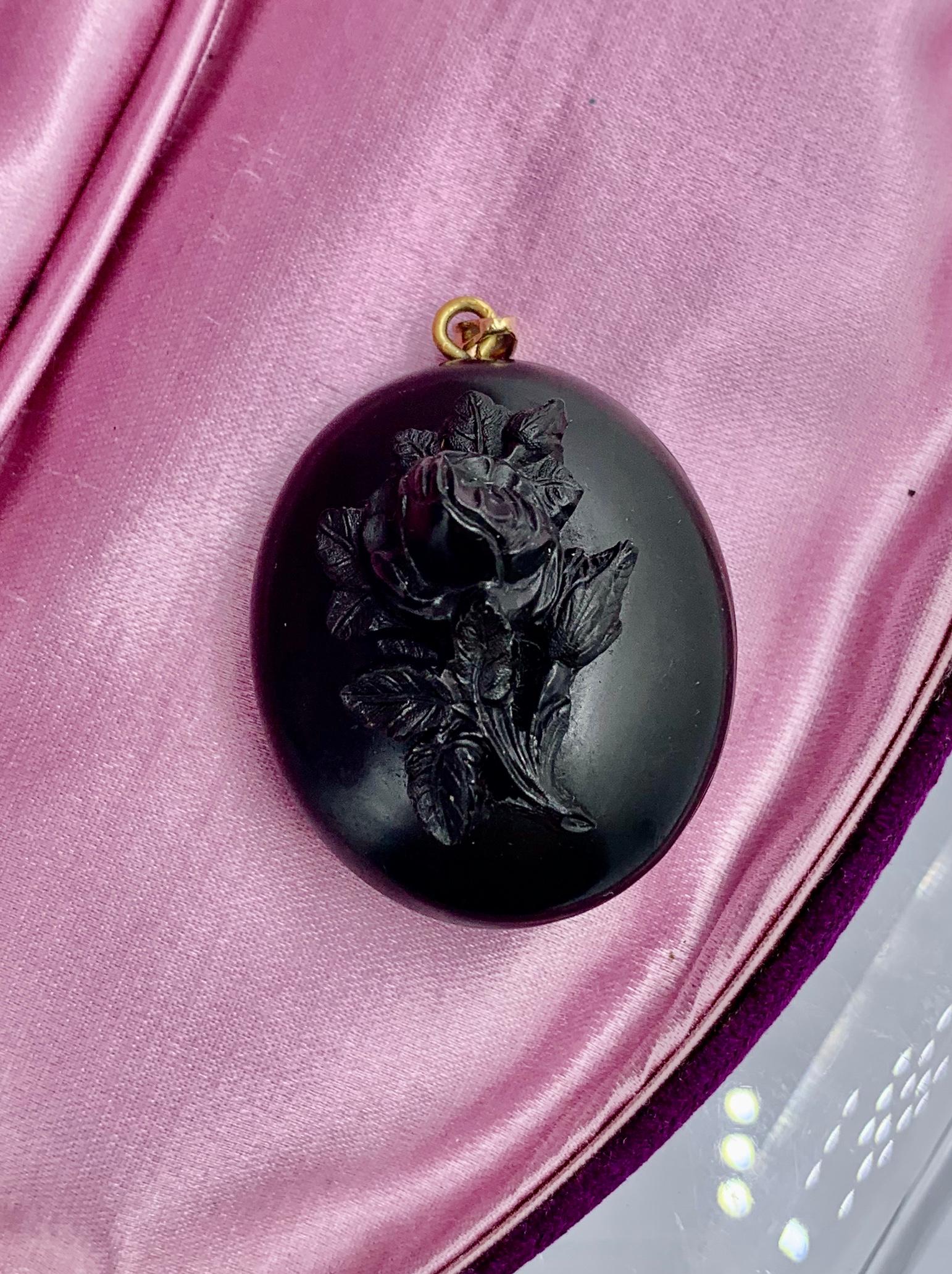 A rare and wonderful Victorian Locket pendant with a gorgeous fully three dimensional depiction of a Rose Flower on the front.  The black locket dates to the Victorian era.  It is Vulcanite.   The bale is 14 Karat Gold.  The very special piece opens