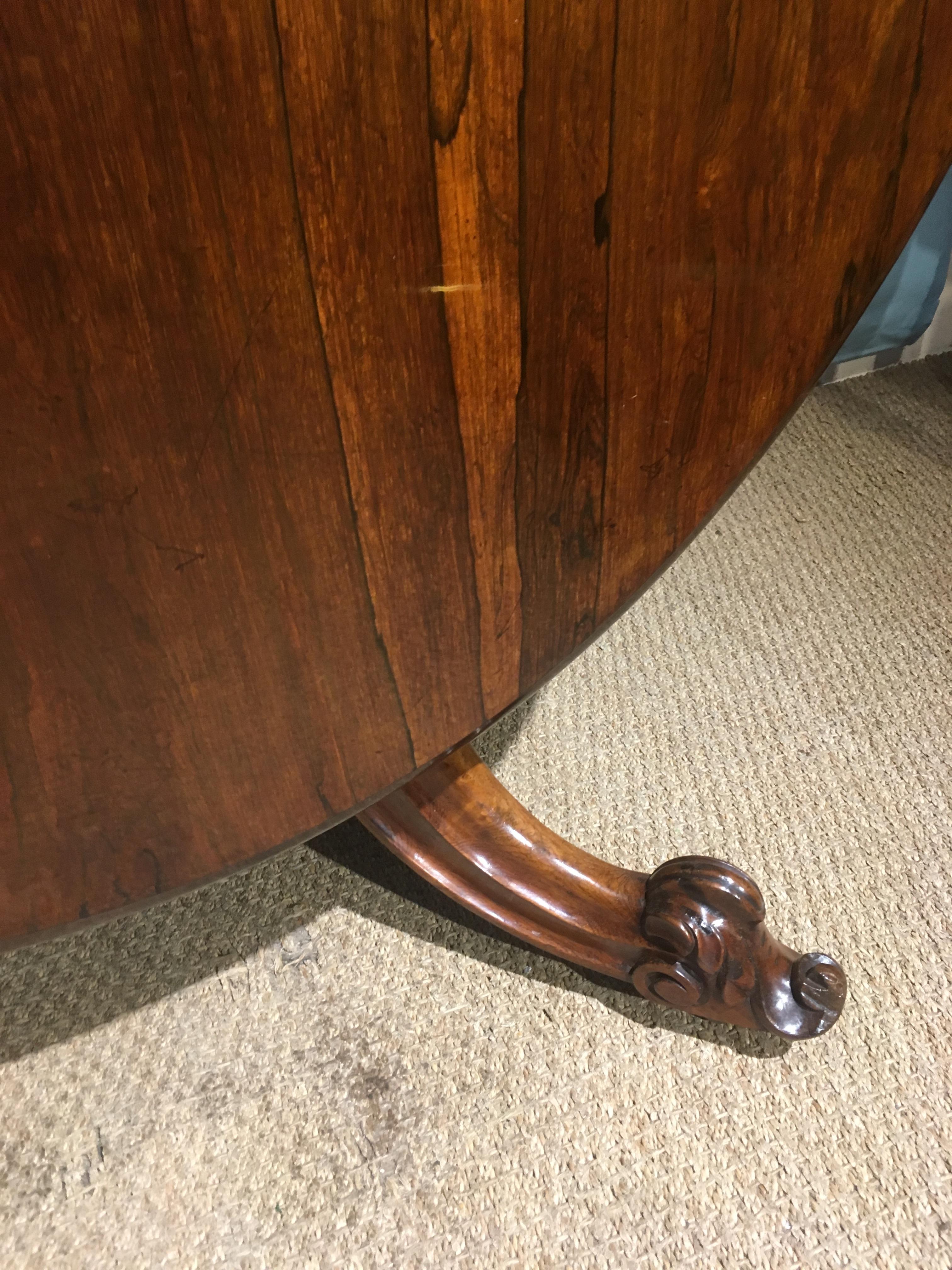 Wonderful mid-19th century figured rosewood Loo table / centre table / dining table 

English, circa 1860s, solid rosewood base with figured rosewood veneered top, with porcelain castors and original brass fixings.

This table has been through