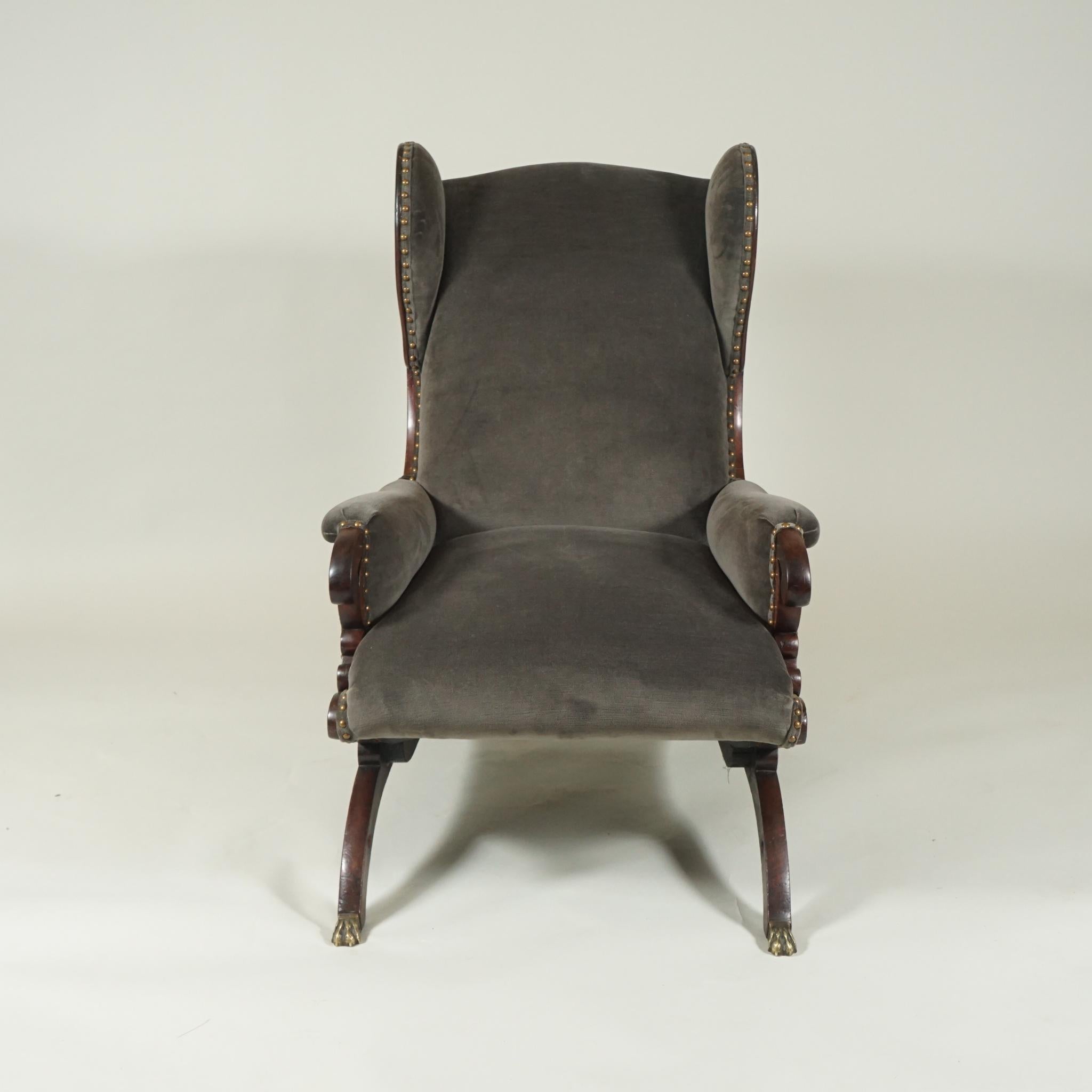 Victorian wing back lounge chair, in polished mahogany, hand carved, newly upholstered in smokey-grey mohair, with brass studs, great for a library or fireside chat.