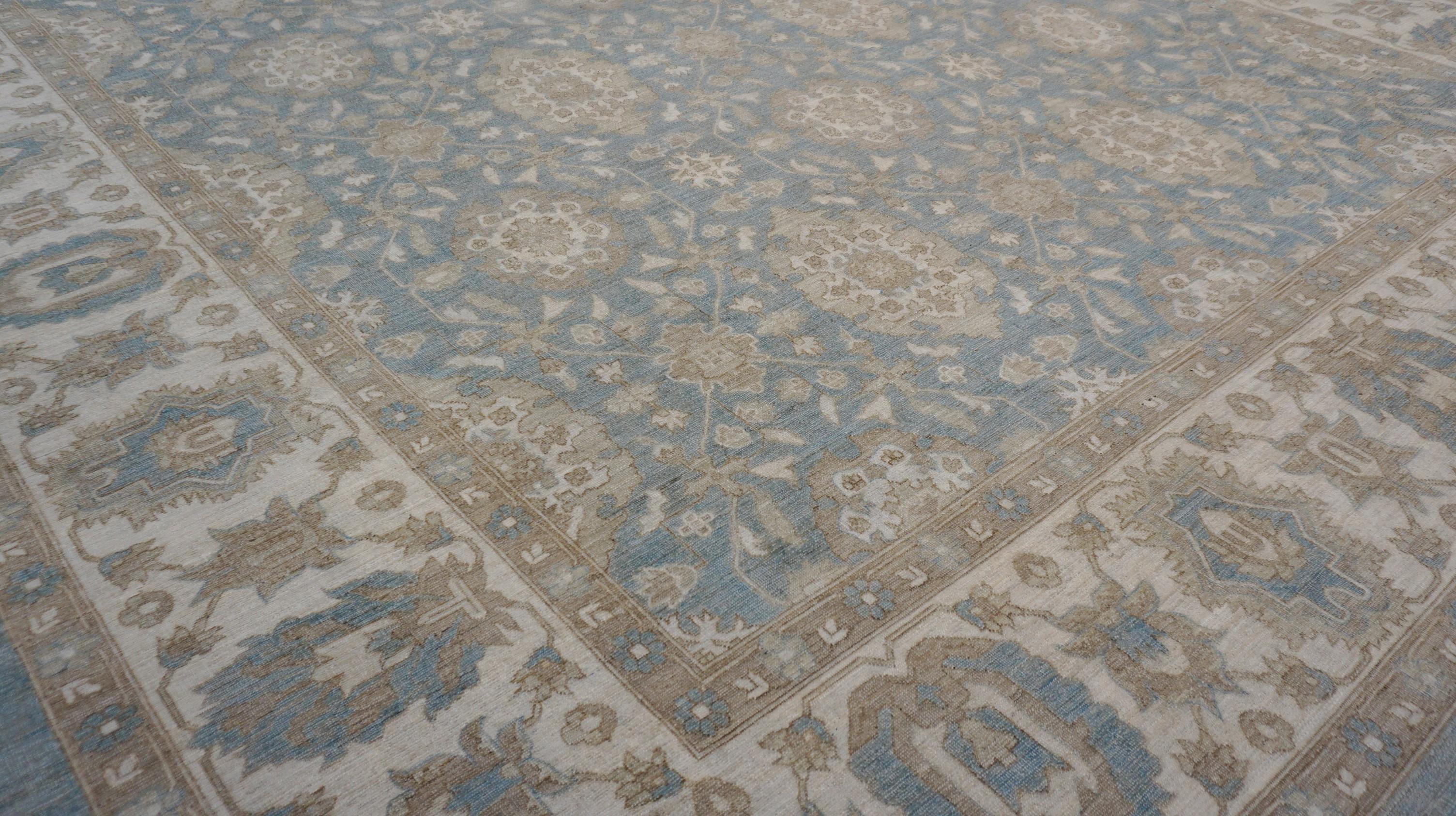Dieser handgeknüpfte Wollteppich zeigt ein exquisites, von Ziegler inspiriertes Blumenmuster, handgeknüpft in einer zarten Farbpalette aus sanftem Blau, Hellbraun, Taupe und Elfenbein. Das aufwändige, sich wiederholende botanische Allover-Muster
