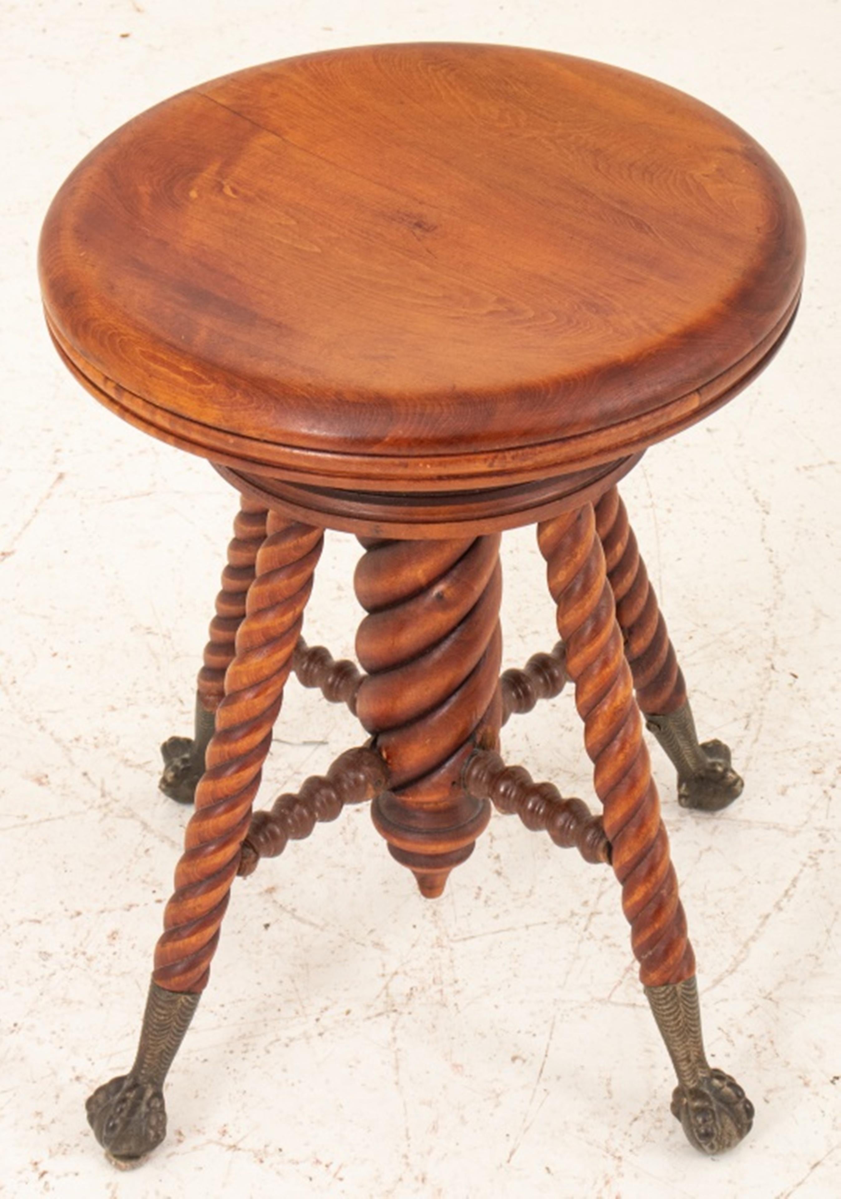 Victorian mahogany adjustable stool with twisted-form central column concealing rise mechanism and four similar legs terminating in brass paw feet.
Dimensions: 18