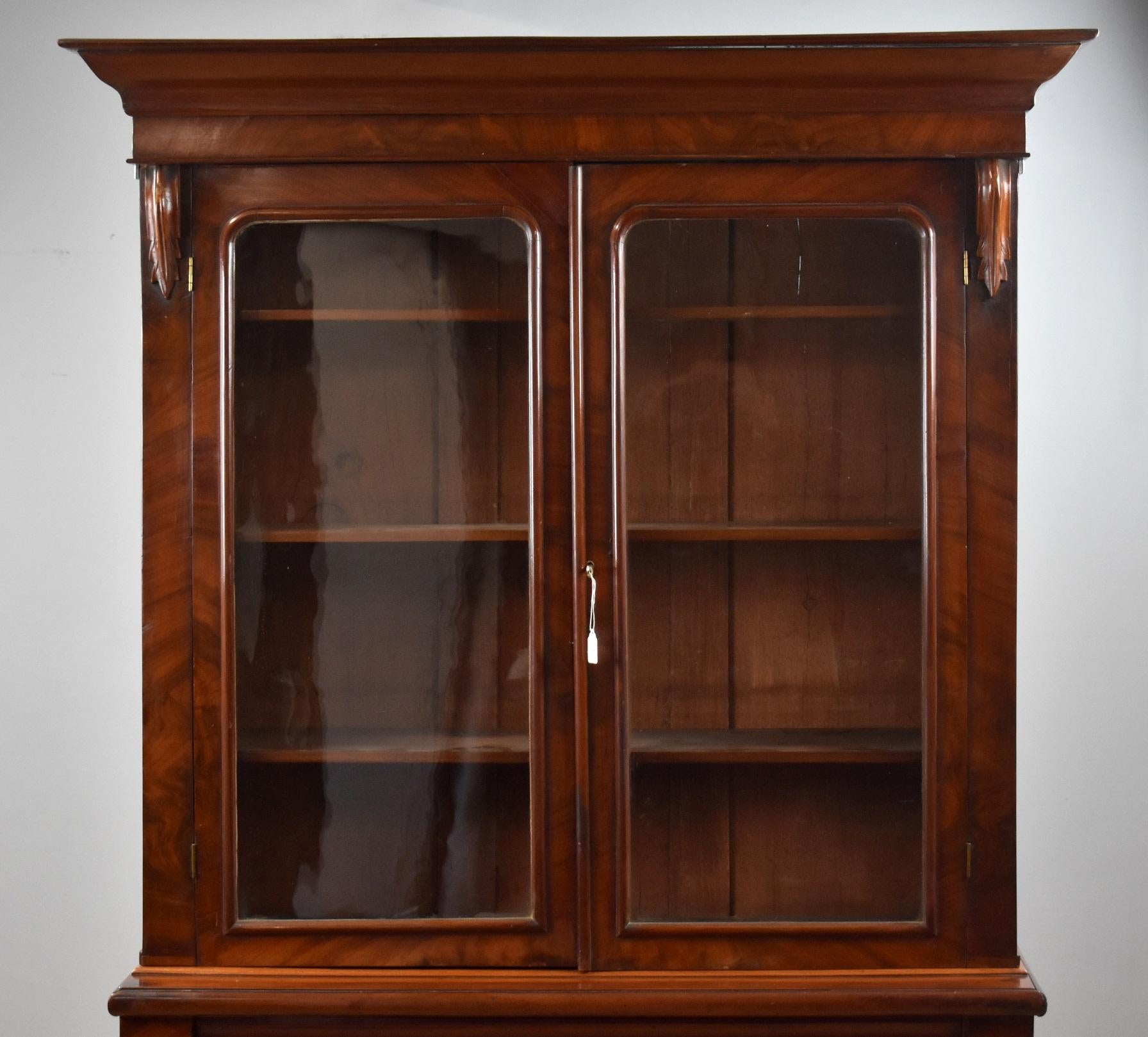 Victorian mahogany library bookcase in good condition having been polished by hand. The bookcase has a pediment top with two glazed doors enclosing three adjustable shelves below this it has a drawer with cupboards with single shelf. With keys.