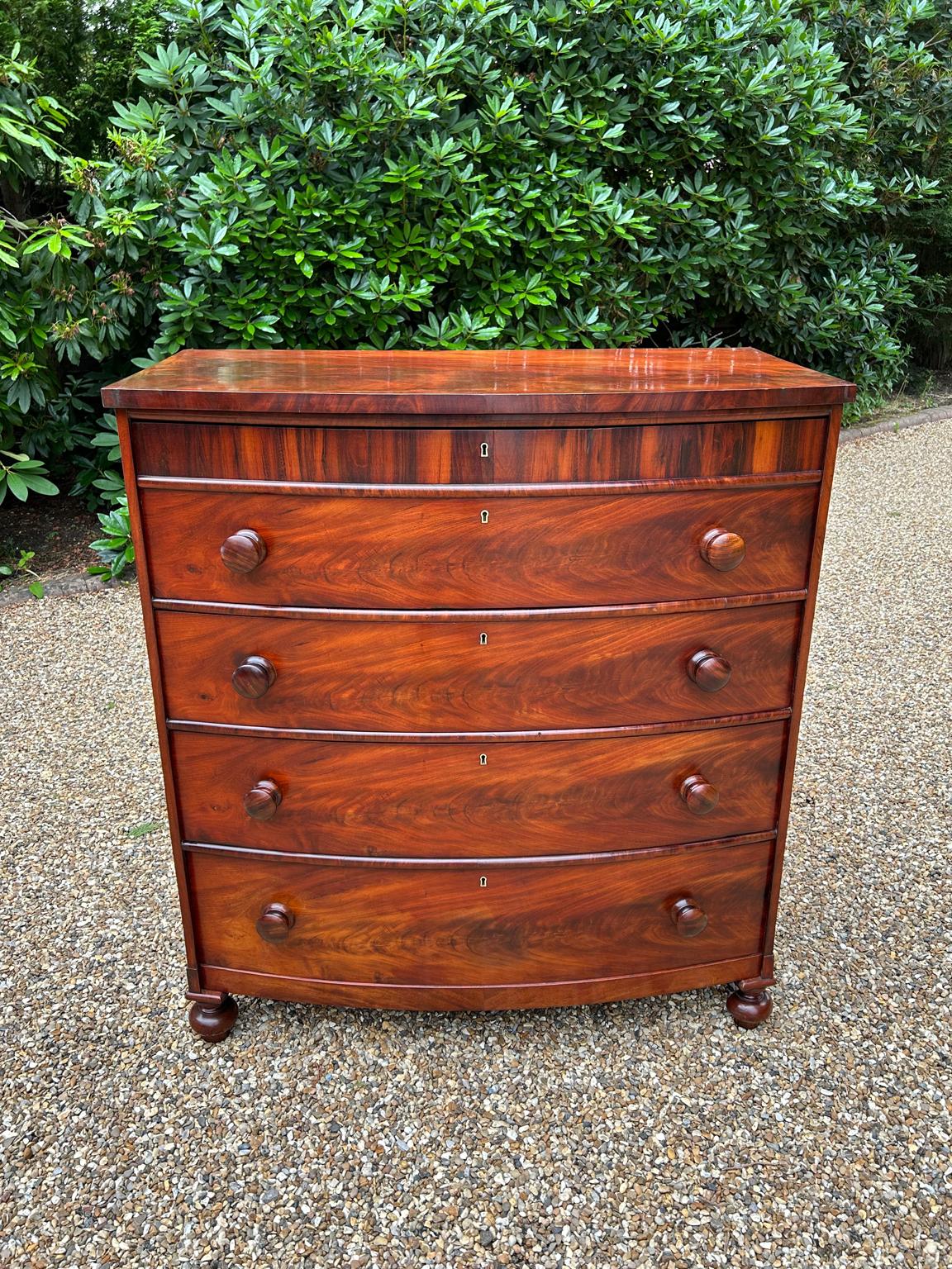 A 19th Century Victorian Mahogany Bow Fronted Chest of Drawers, with four long graduated drawers with turned bun handles raised upon turned feet.

Circa: 1860

Dimensions:
Height:  47.5 inches – 121 cms
Width:   43 inches – 110 cms
Depth:    23.5