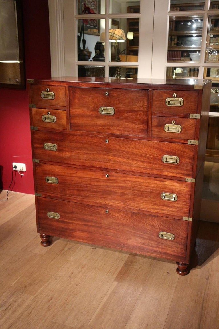 Beautiful mahogany campaign chest of drawers with secretaire in completely original and top condition. We rarely see a copy that is in this condition. There is a water stain on the top. Since it is the original polish layer, we have decided to leave
