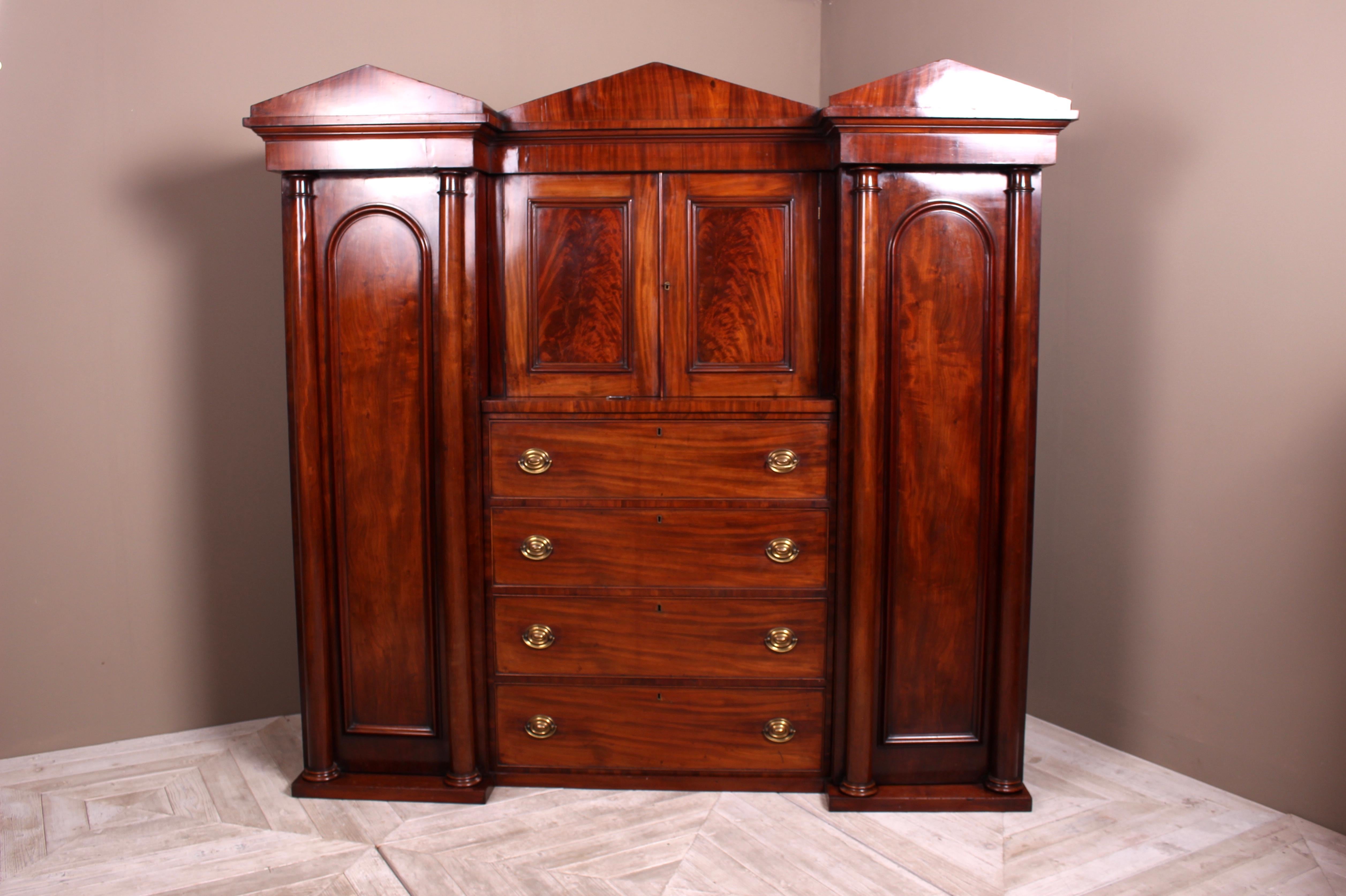 A beautiful Victorian mahogany Compactum wardrobe circa 1850 of good colour and proportions. The architectural cornice sits above central cupboard with lock and key. Below sits a bank of four good sized drawers. Flanked by wardrobes with